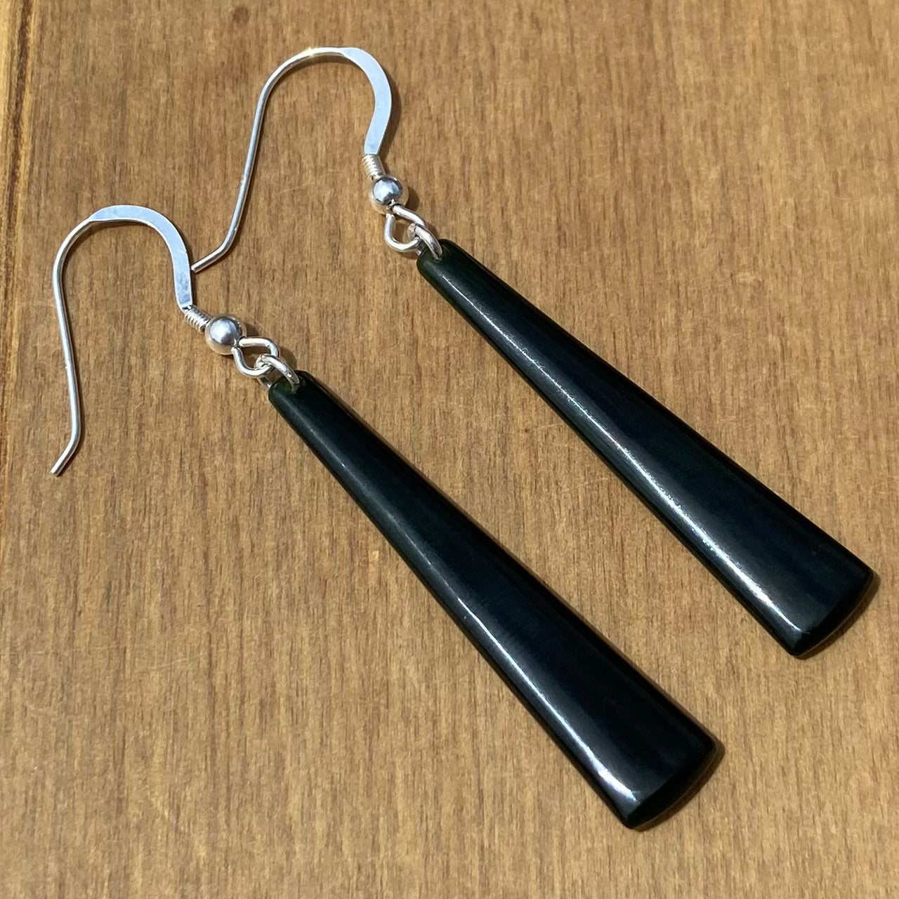 Pair of toki earrings hand-carved from New Zealand Kawakawa Jade/ pounamu (greenstone), with silver fittings. Back.