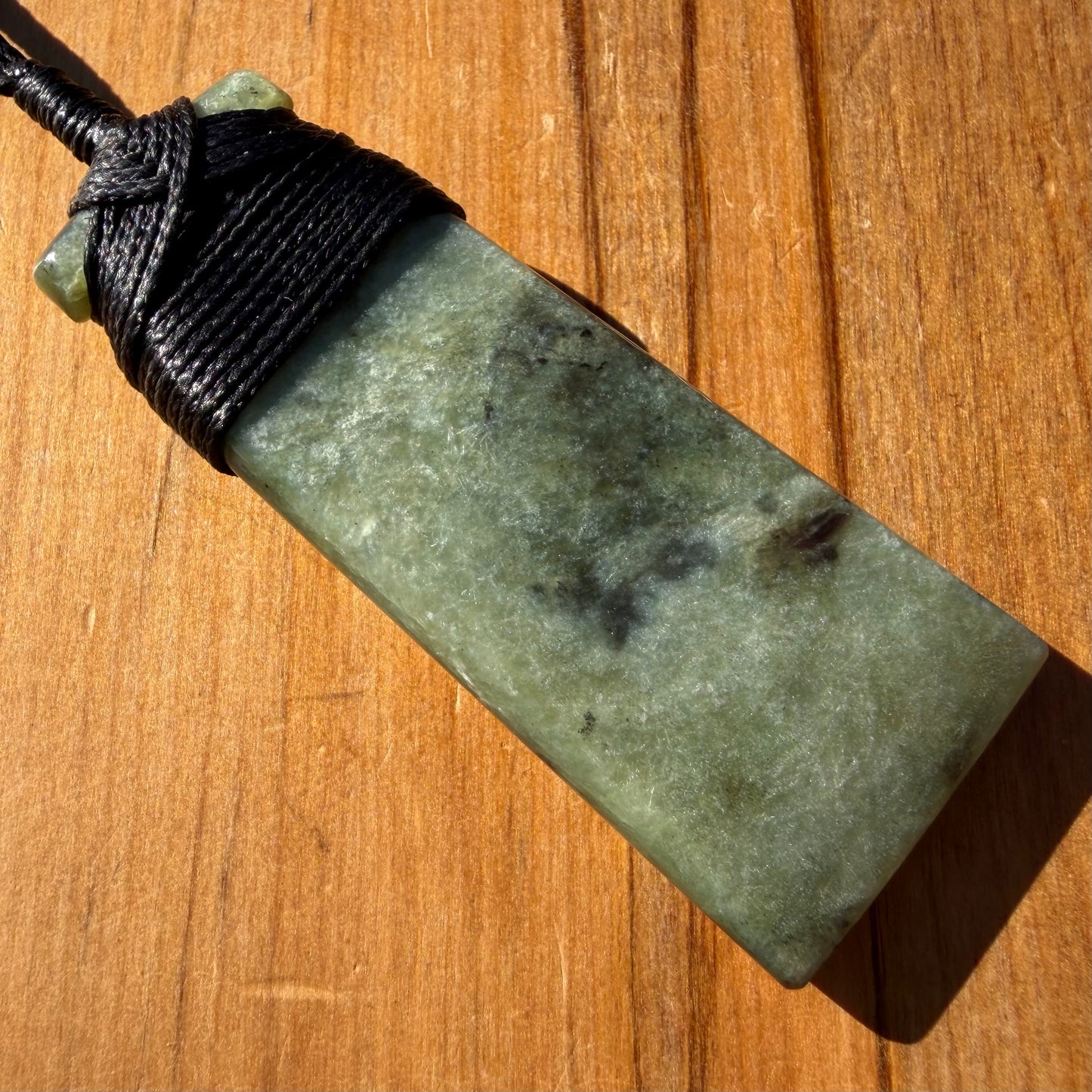 Bound toki pendant hand-carved from NZ Kawakawa pounamu (greenstone). Back.