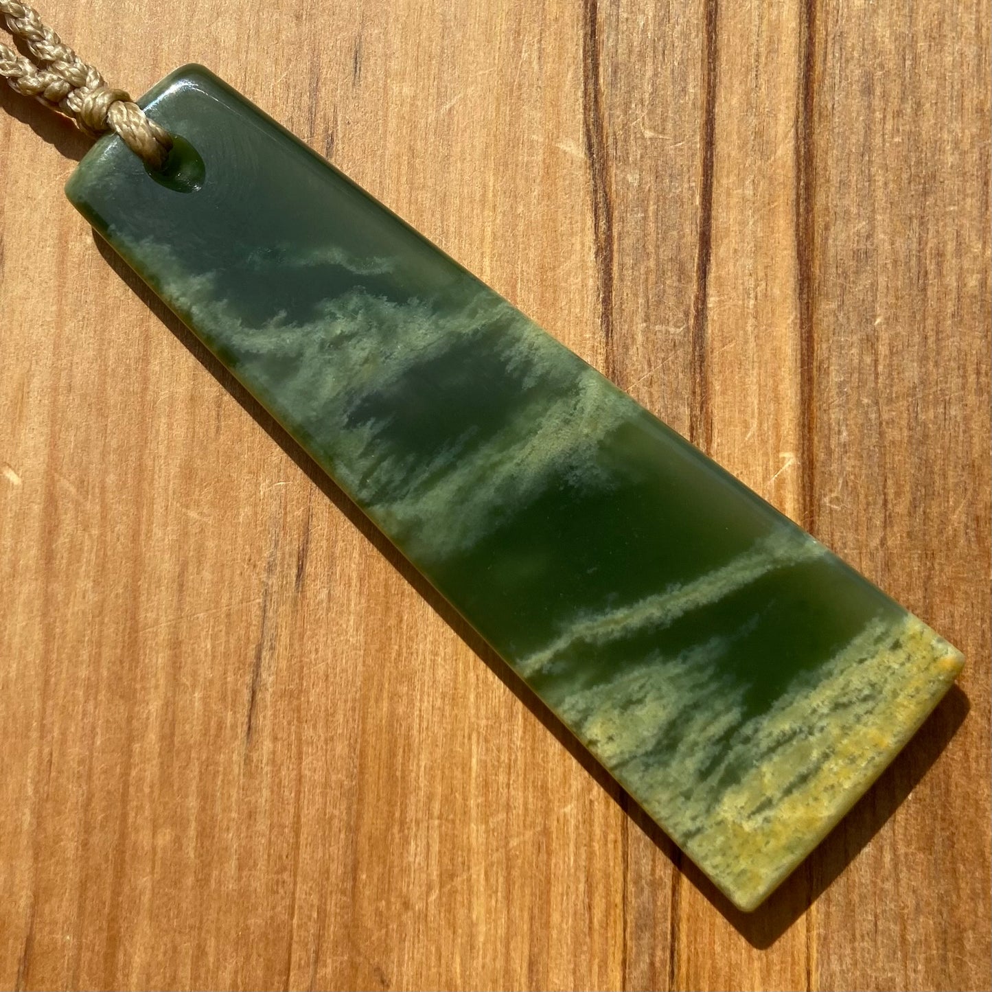 Pounamu toki pendant hand-carved from New Zealand Marsden Flower Jade pounamu (greenstone). Back.