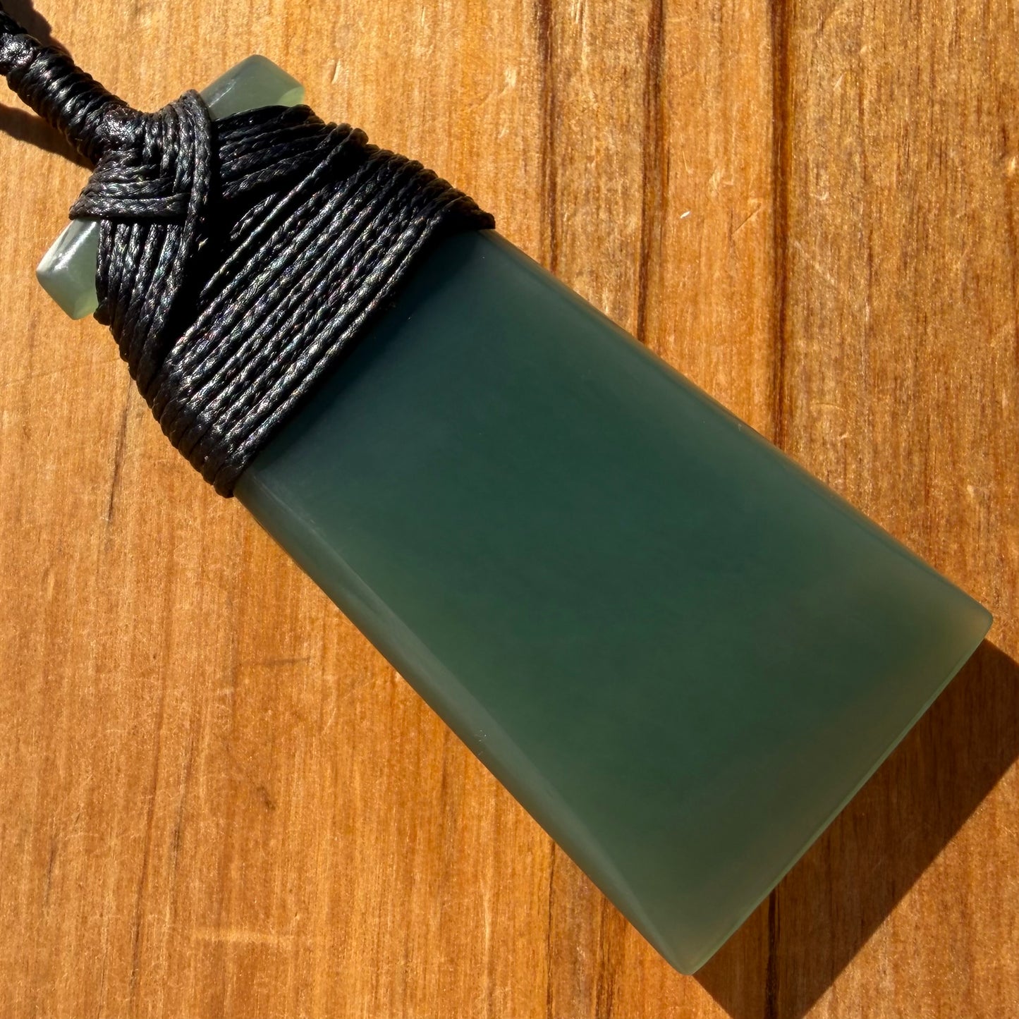 Bound toki pendant hand-carved from New Zealand inanga pounamu (greenstone). Back.