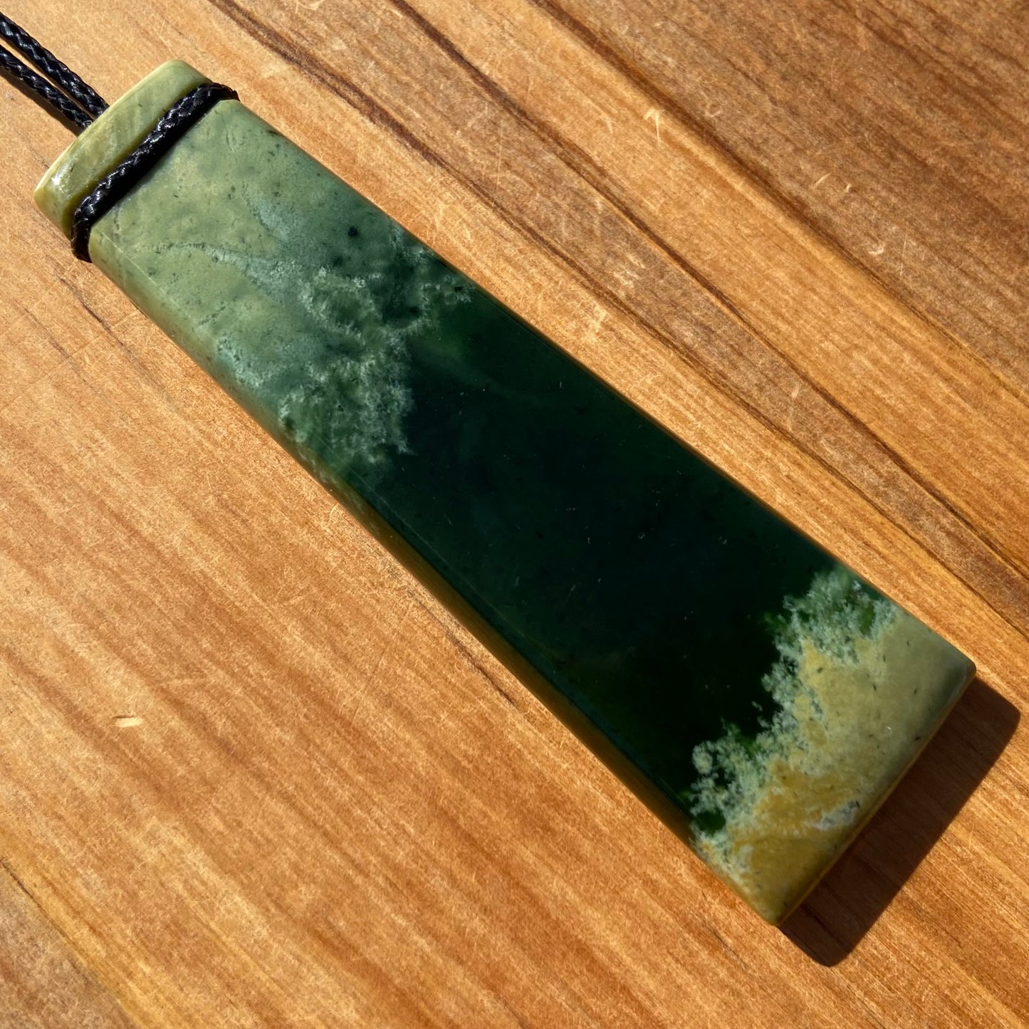 Pounamu toki pendant hand-carved from New Zealand Marsden Flower Jade pounamu (greenstone). Back.