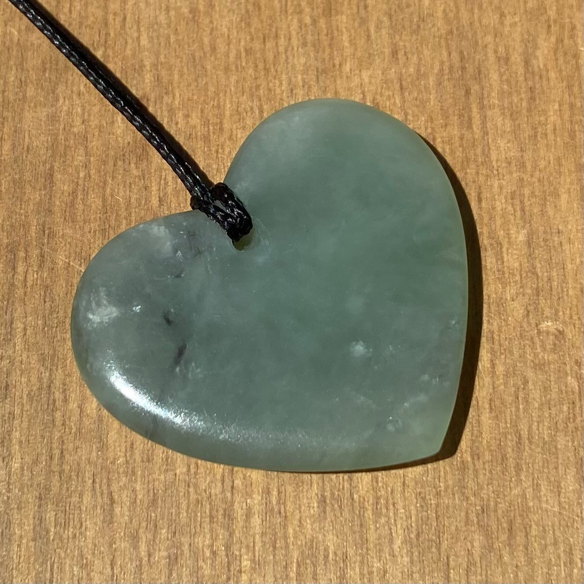 Heart shaped pendant hand-carved from New Zealand inanga pounamu (greenstone). Back.