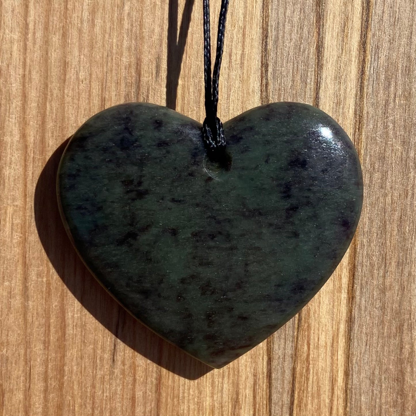 Heart pendant hand-carved from New Zealand totoweka pounamu (greenstone). Back.