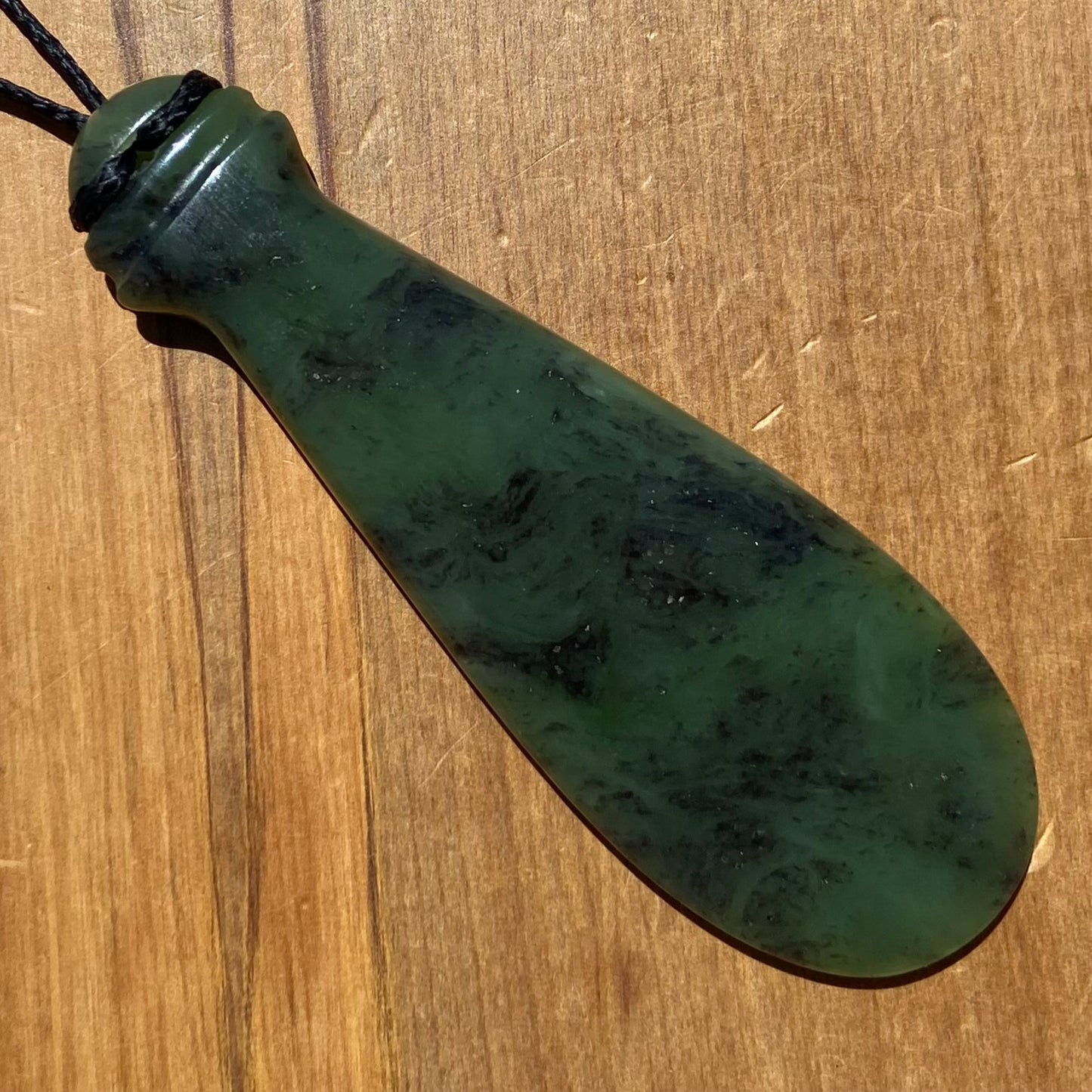 Mere pendant hand-carved from New Zealand Kawakawa pounamu (greenstone). Back.