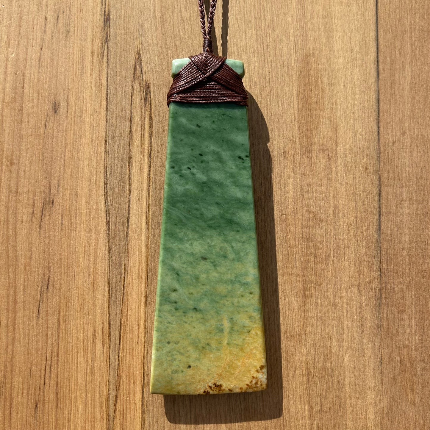 Koru toki pendant hand-carved from New Zealand Marsden Flower Jade/ pounamu (greenstone). Back.