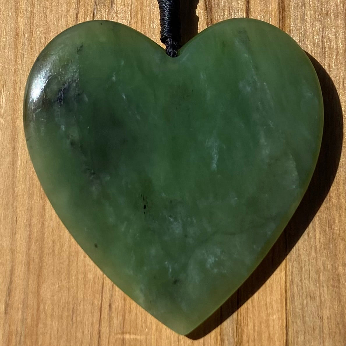 Heart pendant hand-carved from New Zealand kawawkawa pounamu (greenstone). Front.