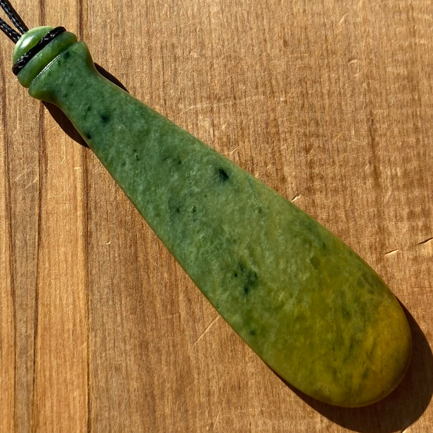Mere pendant hand-carved from New Zealand Marsden Flower jade pounamu (greenstone). Back.