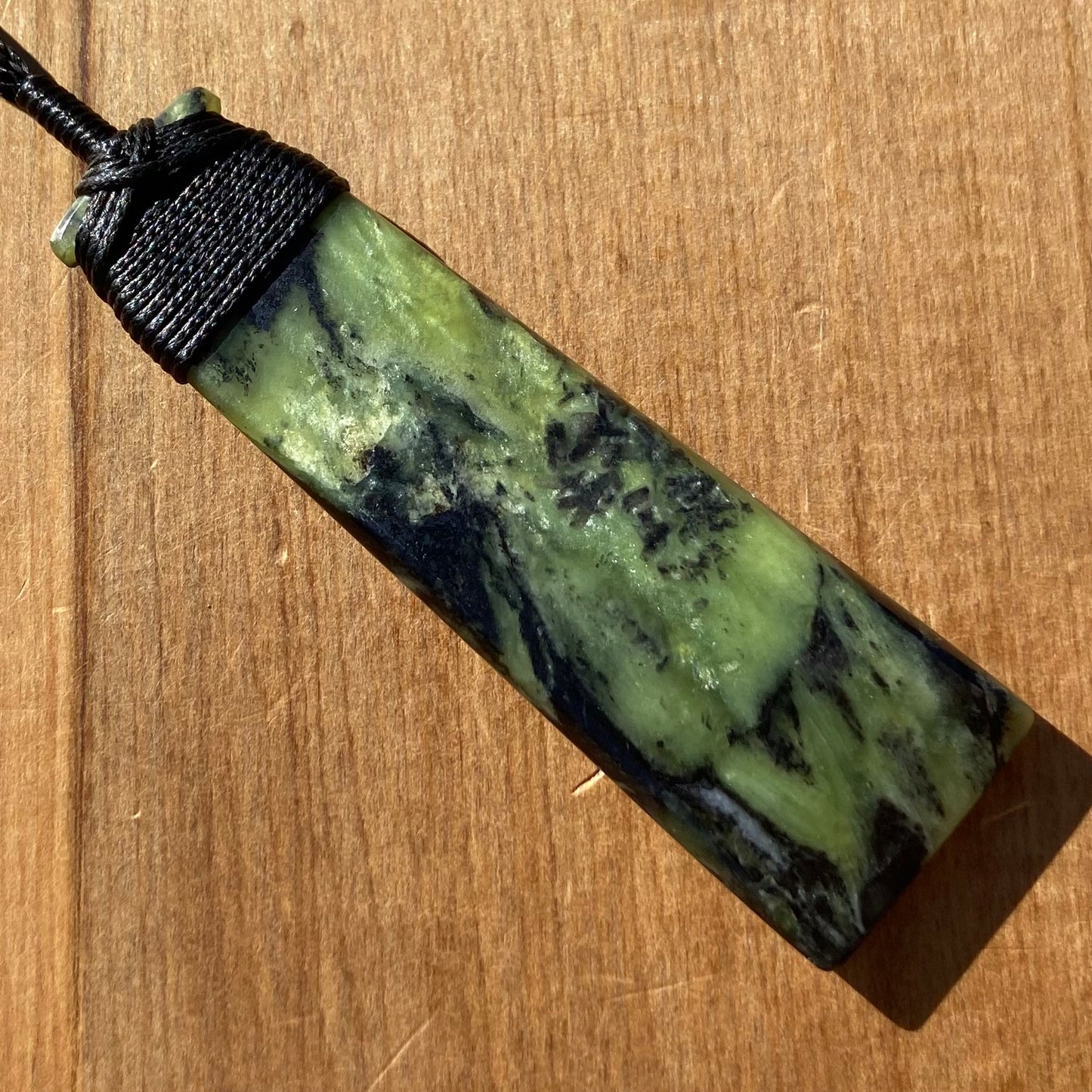 Bound toki pendant hand-carved from New Zealand Douglas Creek pounamu (greenstone). Front.