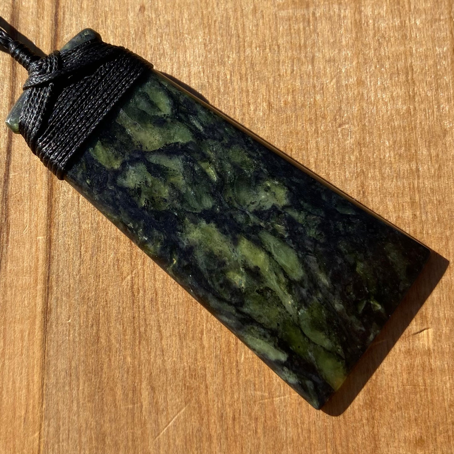 Bound toki pendant hand-carved from New Zealand Douglas Creek pounamu (greenstone). Front.