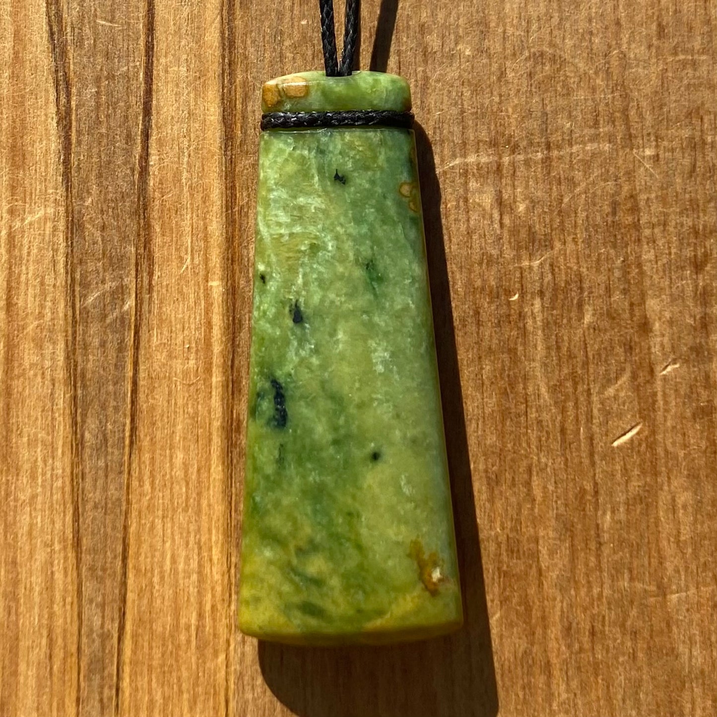 Pounamu toki pendant hand-carved from New Zealand Marsden Flower Jade pounamu (greenstone). Front.