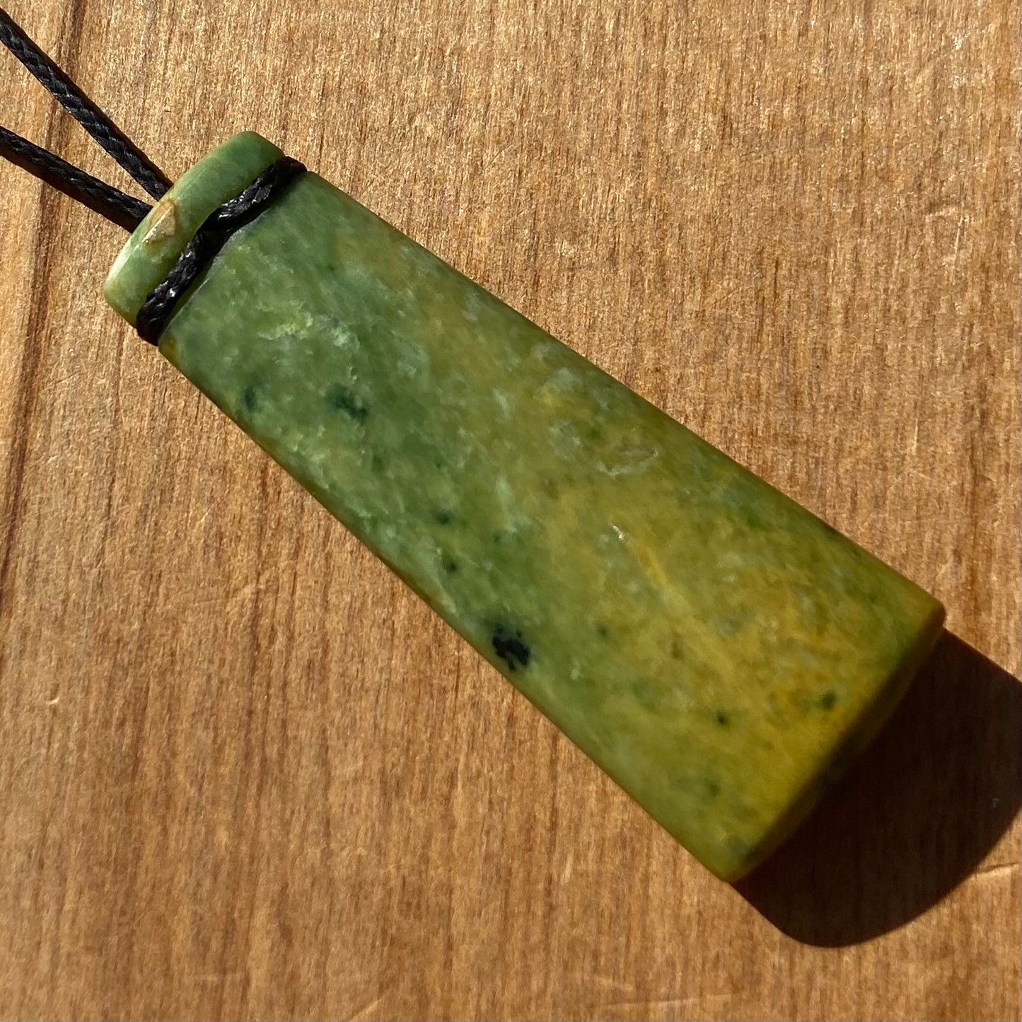 Pounamu toki pendant hand-carved from New Zealand Marsden Flower Jade pounamu (greenstone). Back.