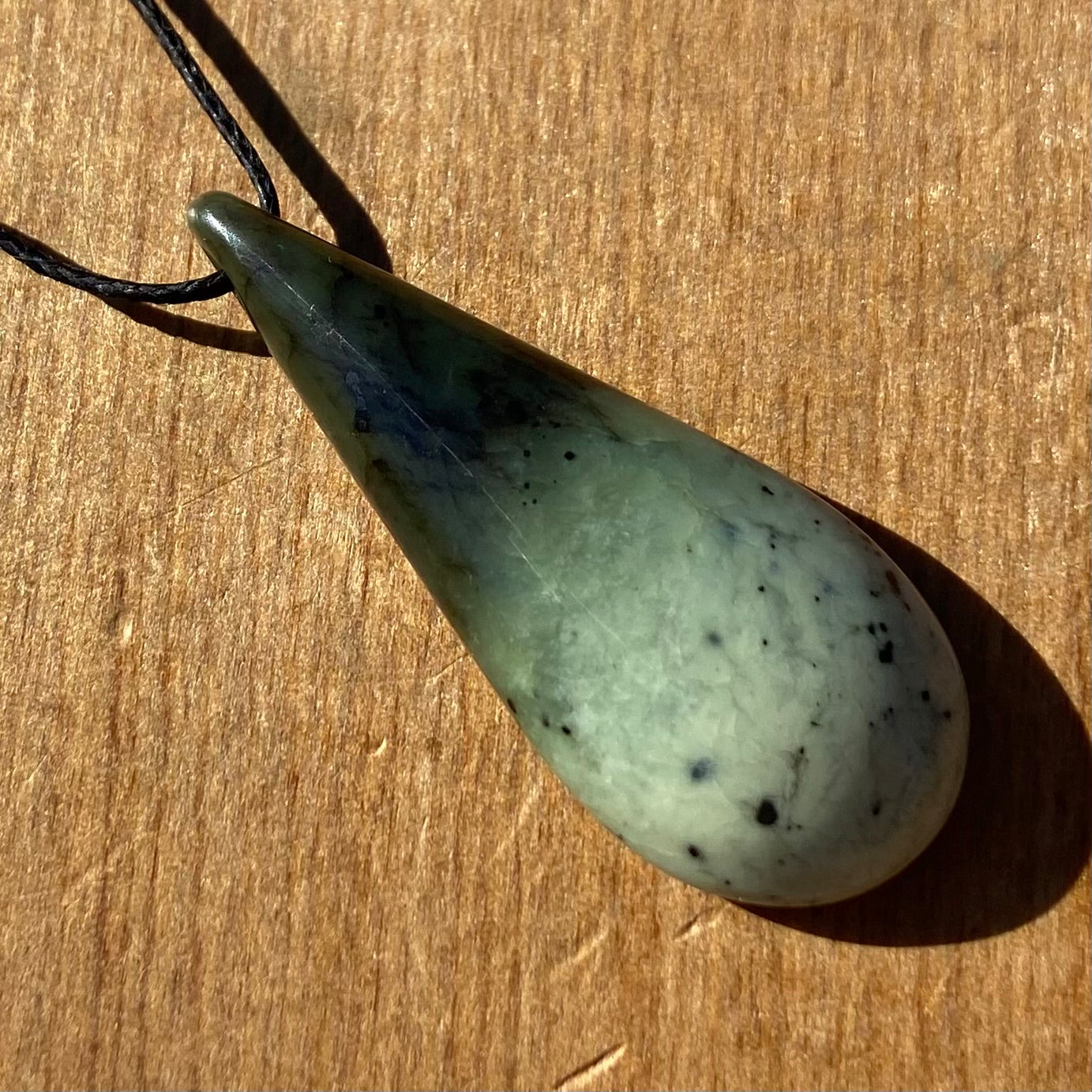 Roimata (teardrop) pendant hand-carved from New Zealand kawakawa pounamu (greenstone). Front.