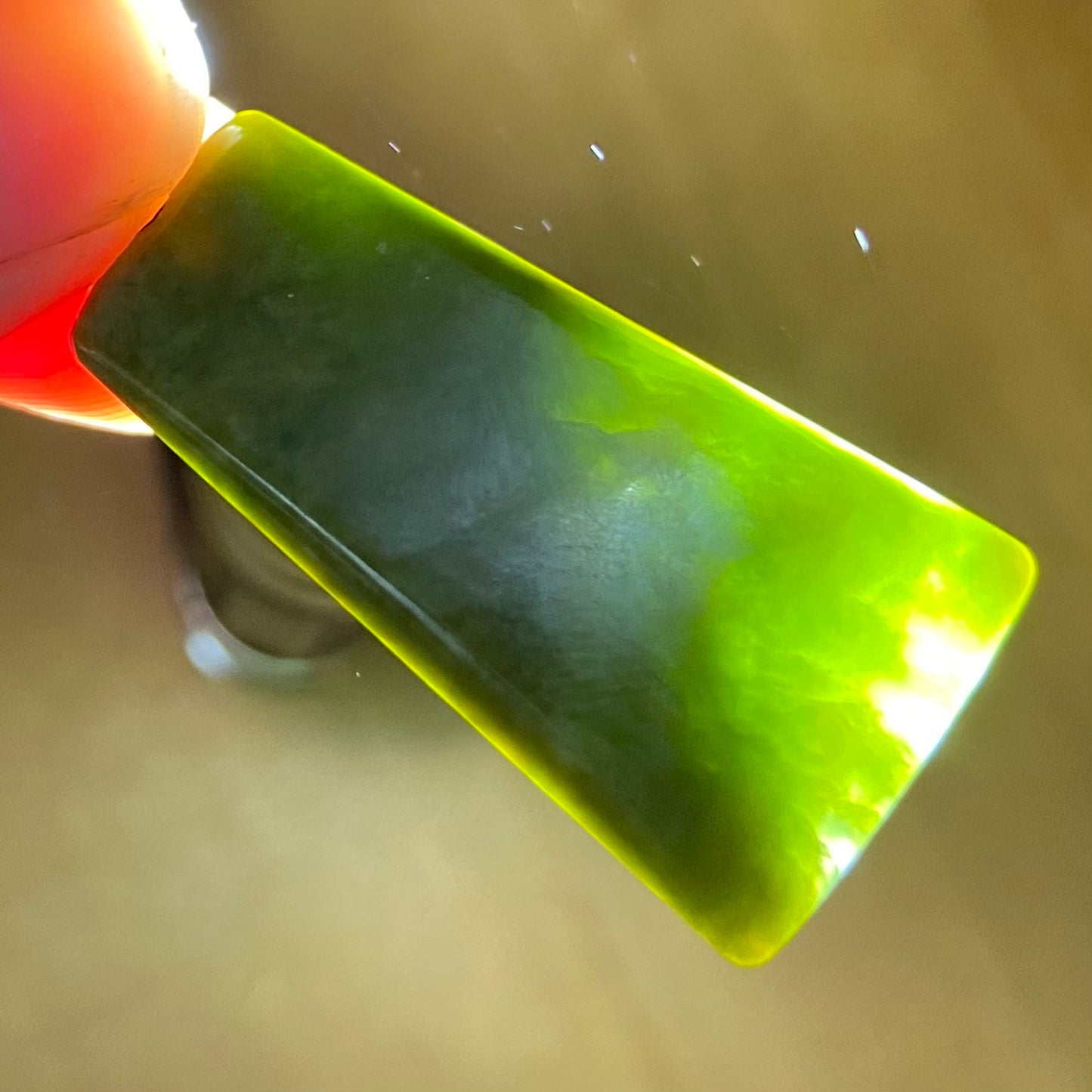 Pounamu toki pendant hand-carved from New Zealand Marsden Flower Jade pounamu (greenstone). Translucency.