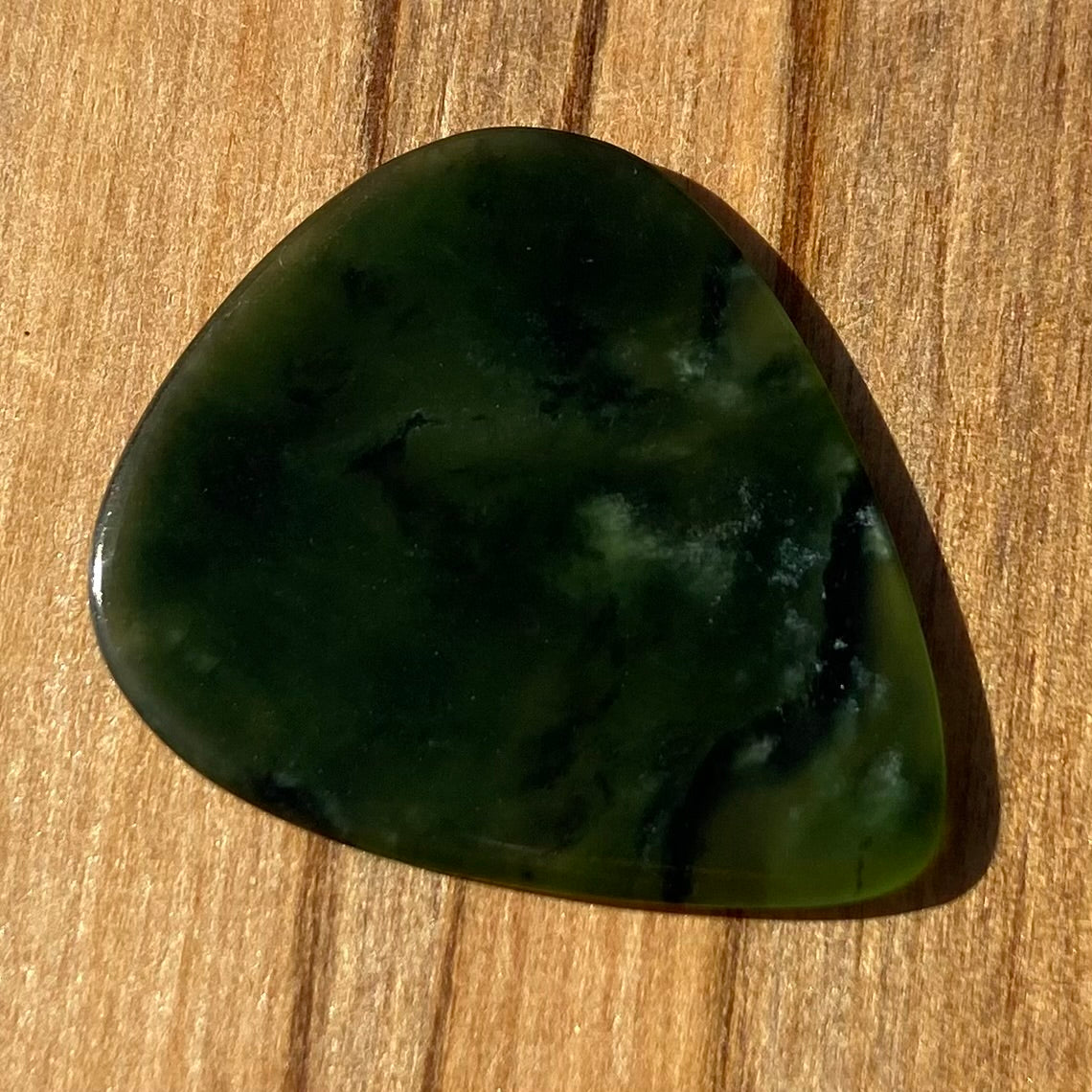 Guitar pick hand-carved from New Zealand Kawakawa Greenstone pounamu (greenstone). Back.