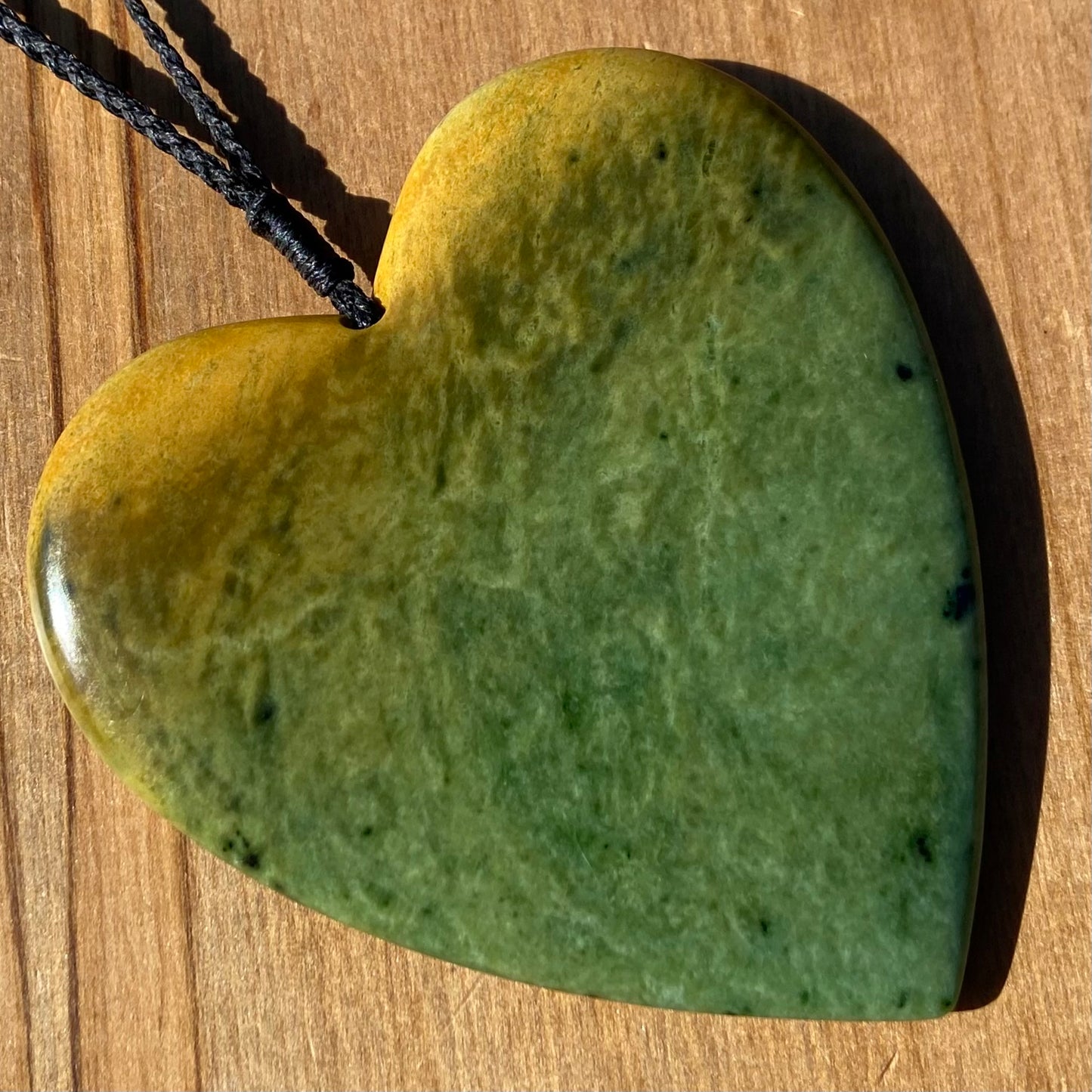 Pounamu heart shape pendant carved from New Zealand Marsden Flower Jade (greenstone). Front. Large