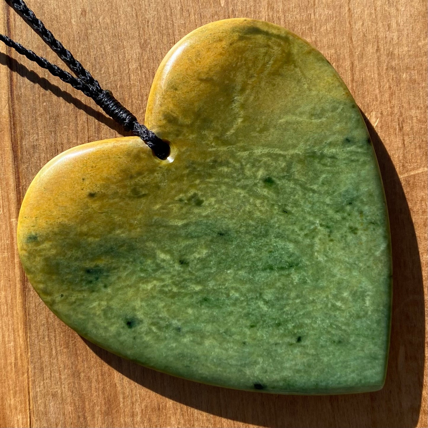 Pounamu heart shape pendant carved from New Zealand Marsden Flower Jade (greenstone). Back. Large.