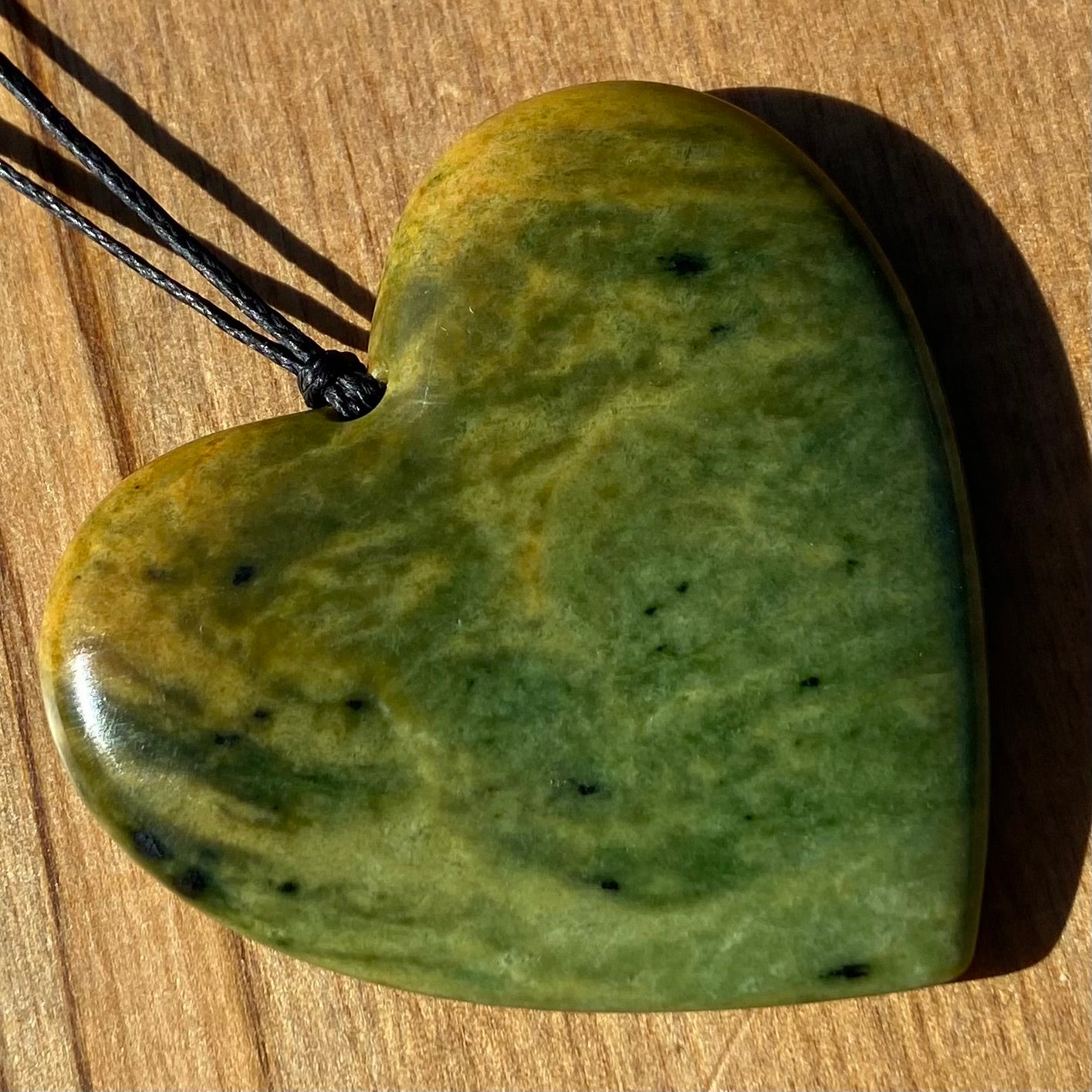 Pounamu heart shape pendant carved from New Zealand Marsden Flower Jade (greenstone). Front.