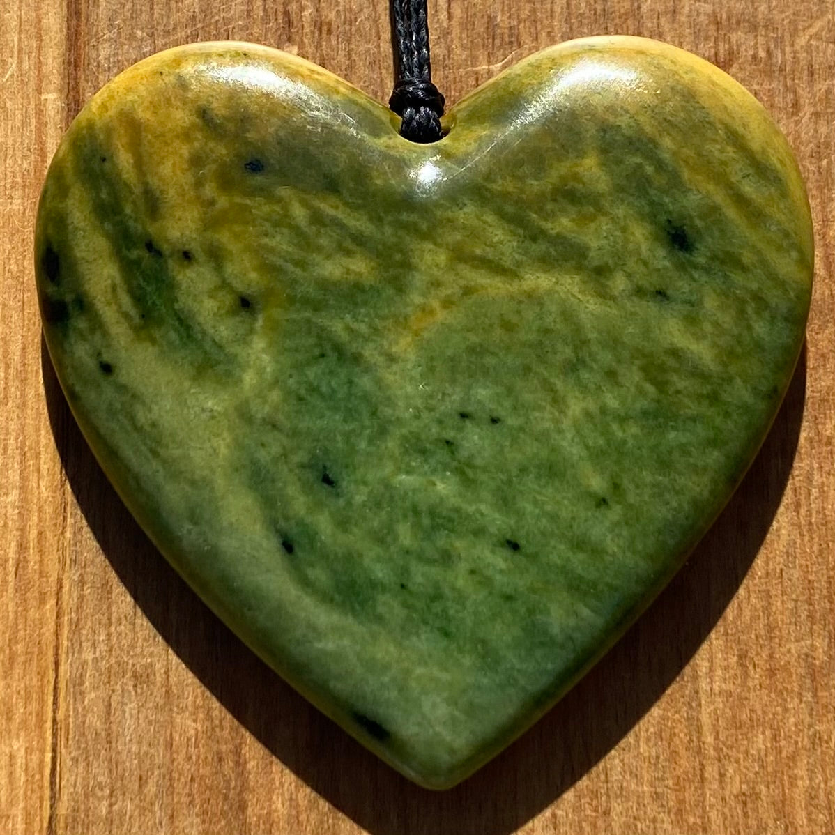 Pounamu heart shape pendant carved from New Zealand Marsden Flower Jade (greenstone). Front.