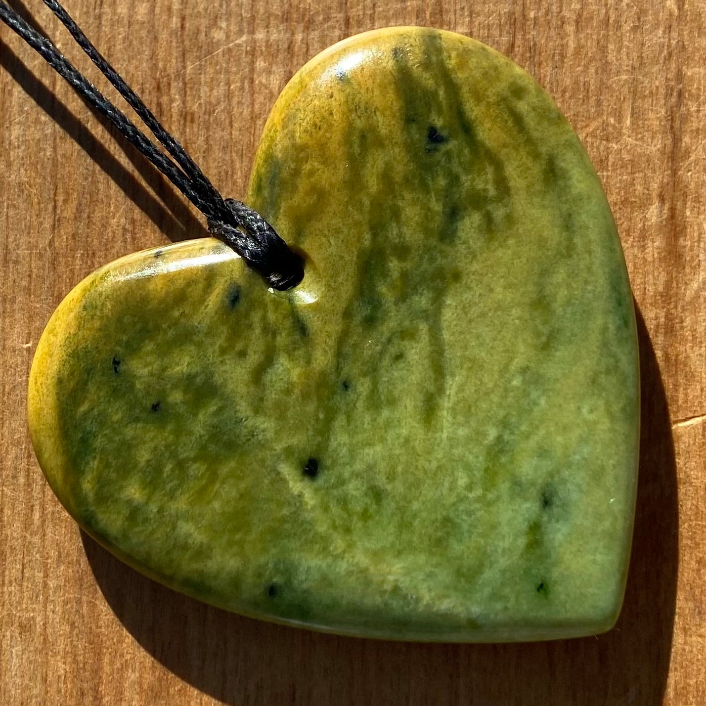 Pounamu heart shape pendant carved from New Zealand Marsden Flower Jade (greenstone). Back.