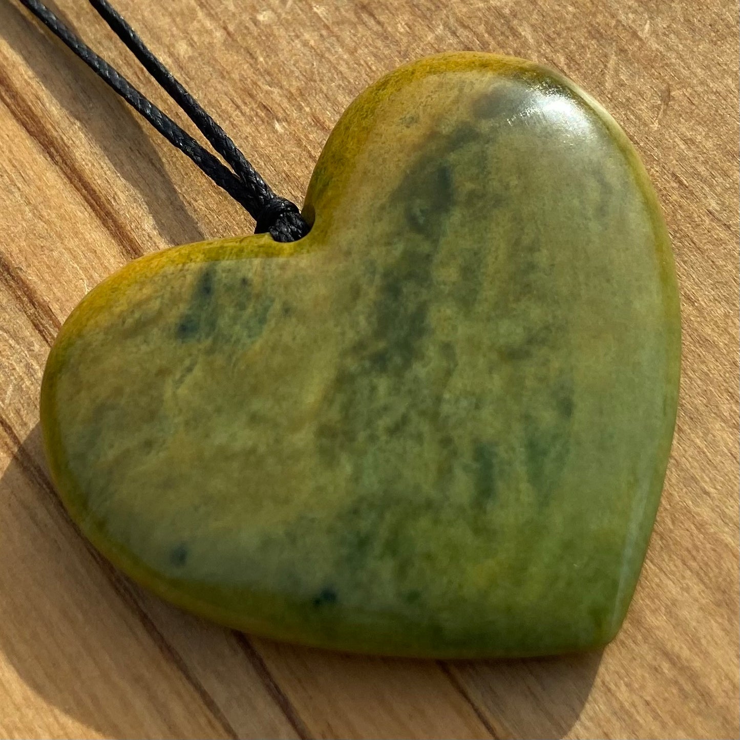 Heart shape pendant carved from New Zealand Marsden Flower Jade (greenstone). Front.