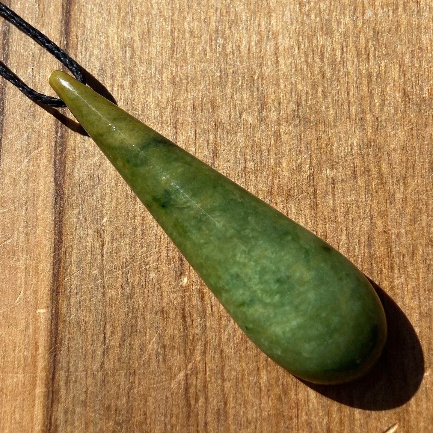 Roimata (teardrop) pendant hand-carved from New Zealand Marsden Flower Jade/ pounamu (greenstone). Front.