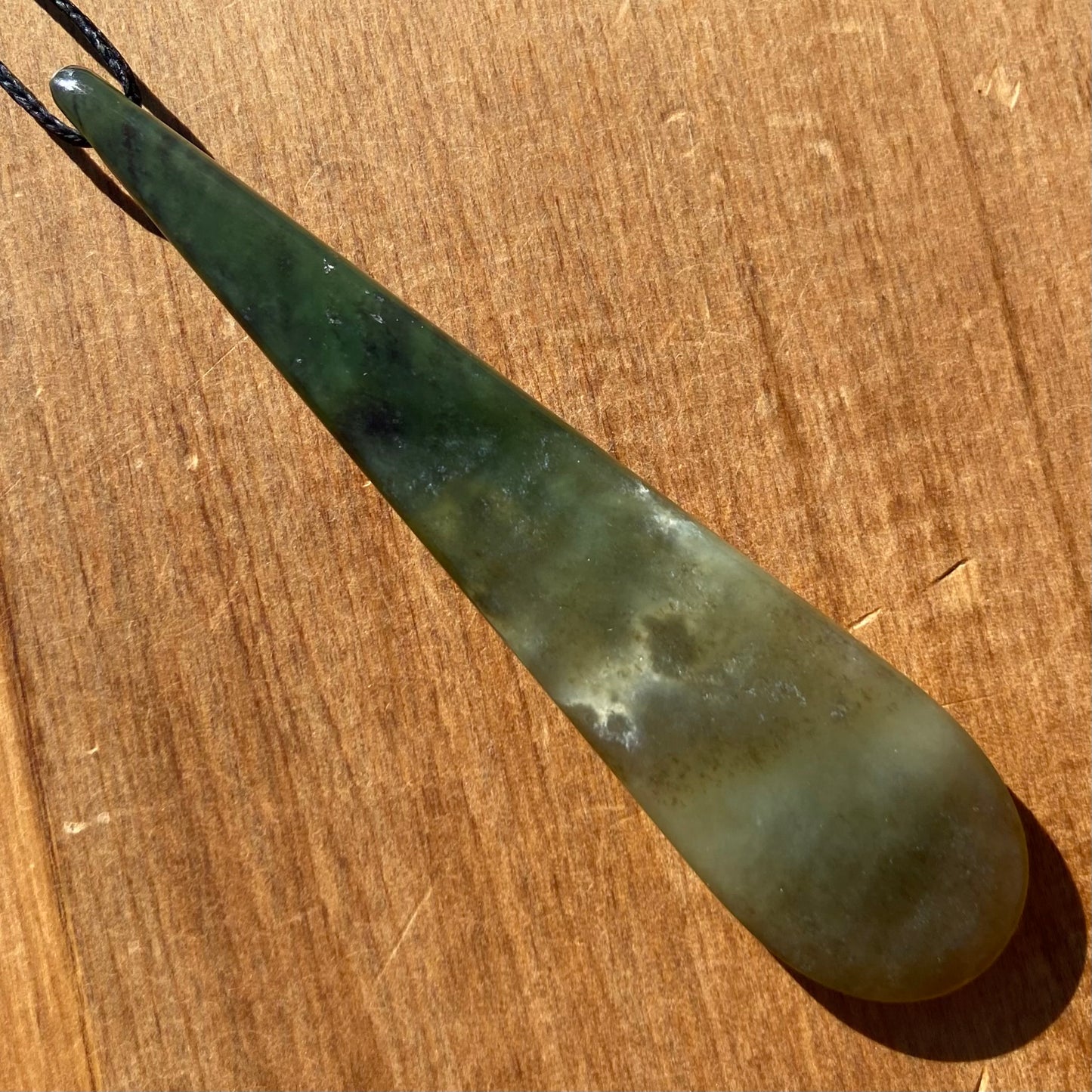 Roimata teardrop pendant hand-carved from New Zealand kawawkawa pounamu (greenstone). Back.