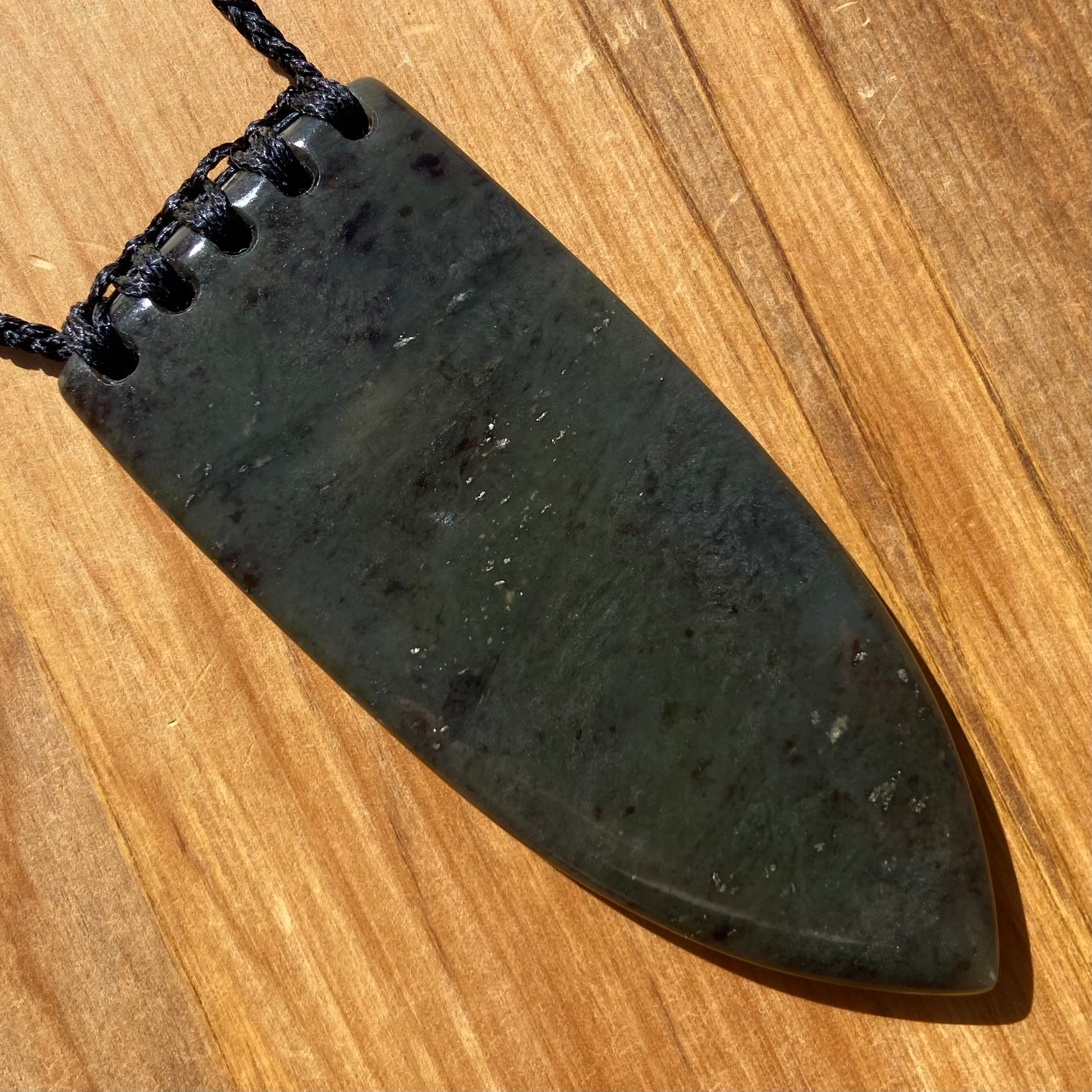 Bound Niho Tooth pendant hand-carved from New Zealand Kawakawa pounamu (greenstone). Back.