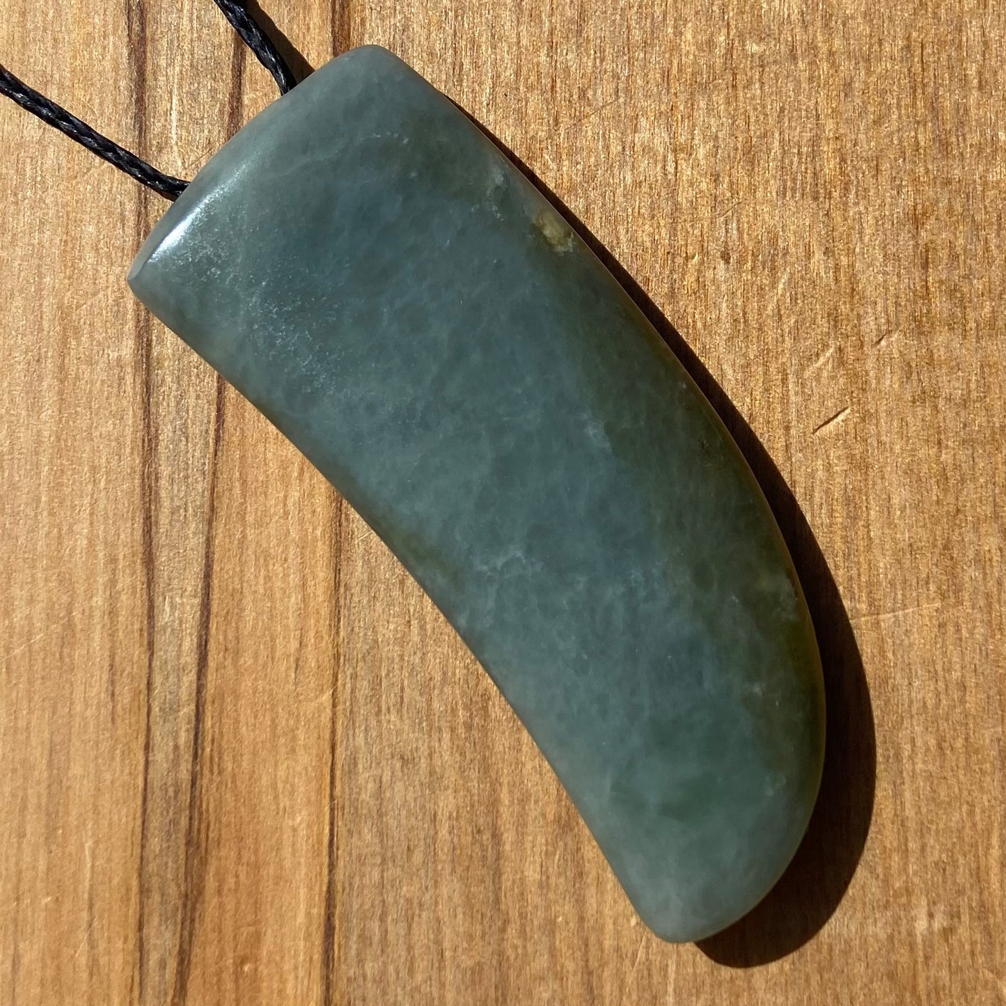 Niho Tooth pendant hand-carved from New Zealand inanga pounamu (greenstone). Front.