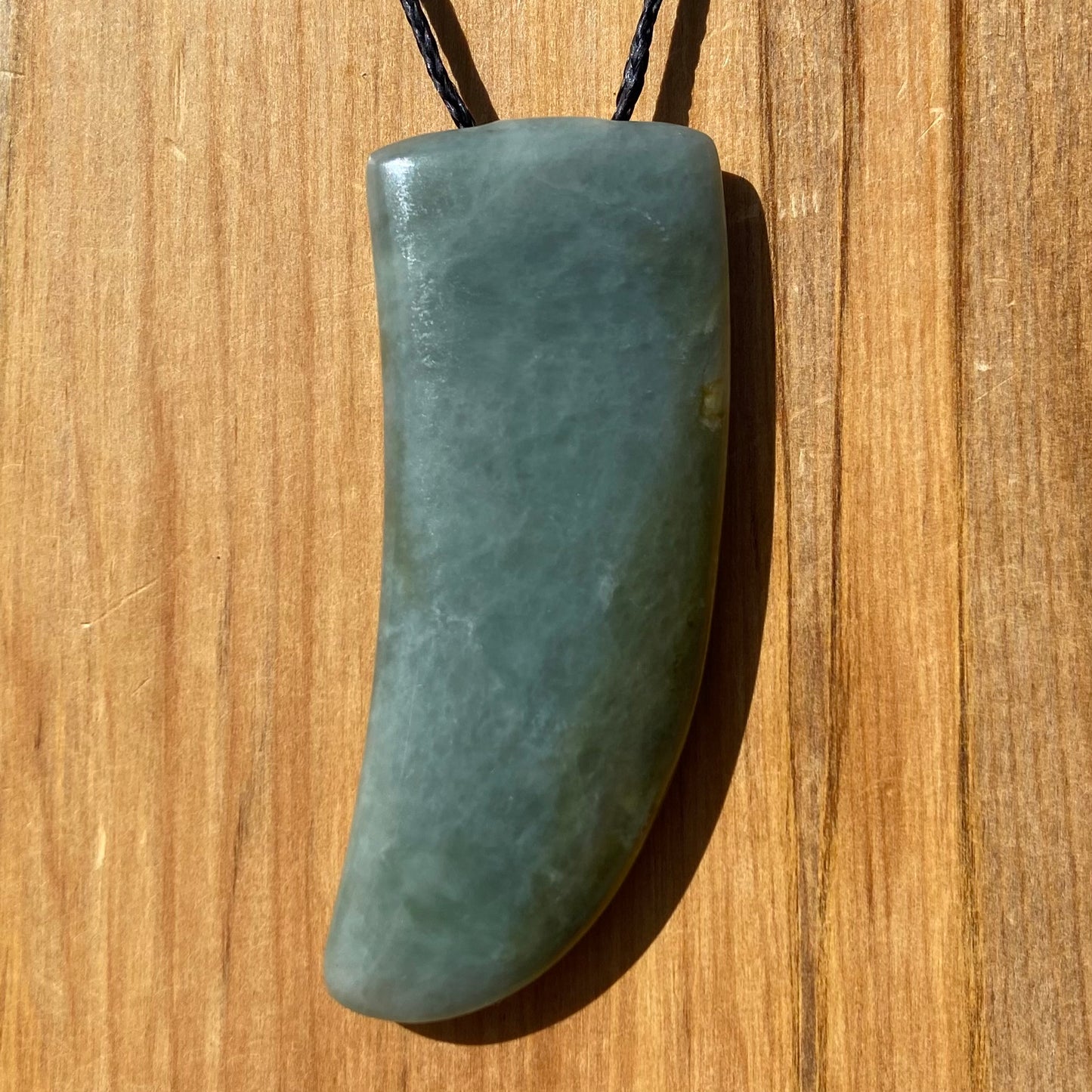 Niho Tooth pendant hand-carved from New Zealand inanga pounamu (greenstone). Front.