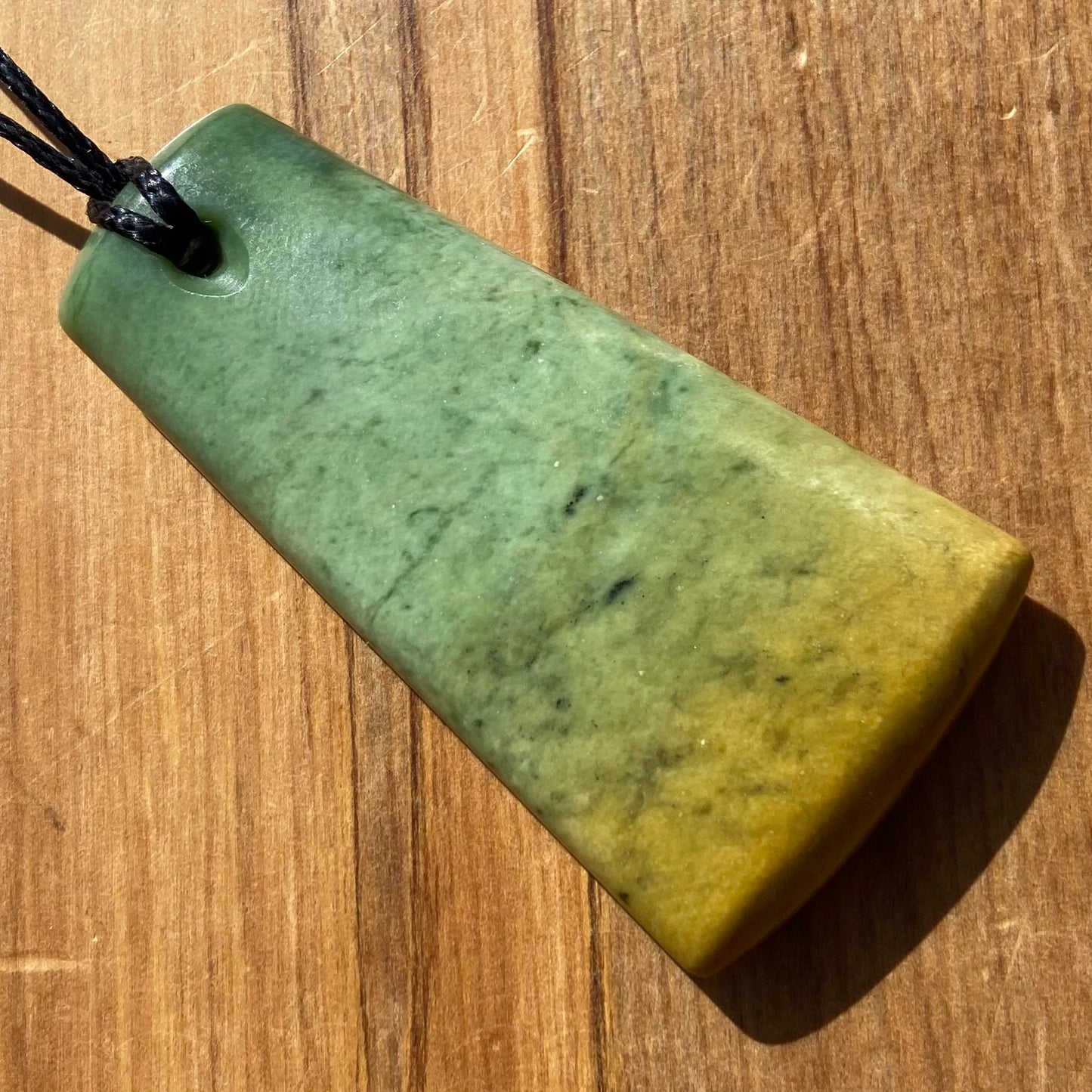 Pounamu toki pendant hand-carved from New Zealand Marsden Flower Jade pounamu (greenstone). Back.