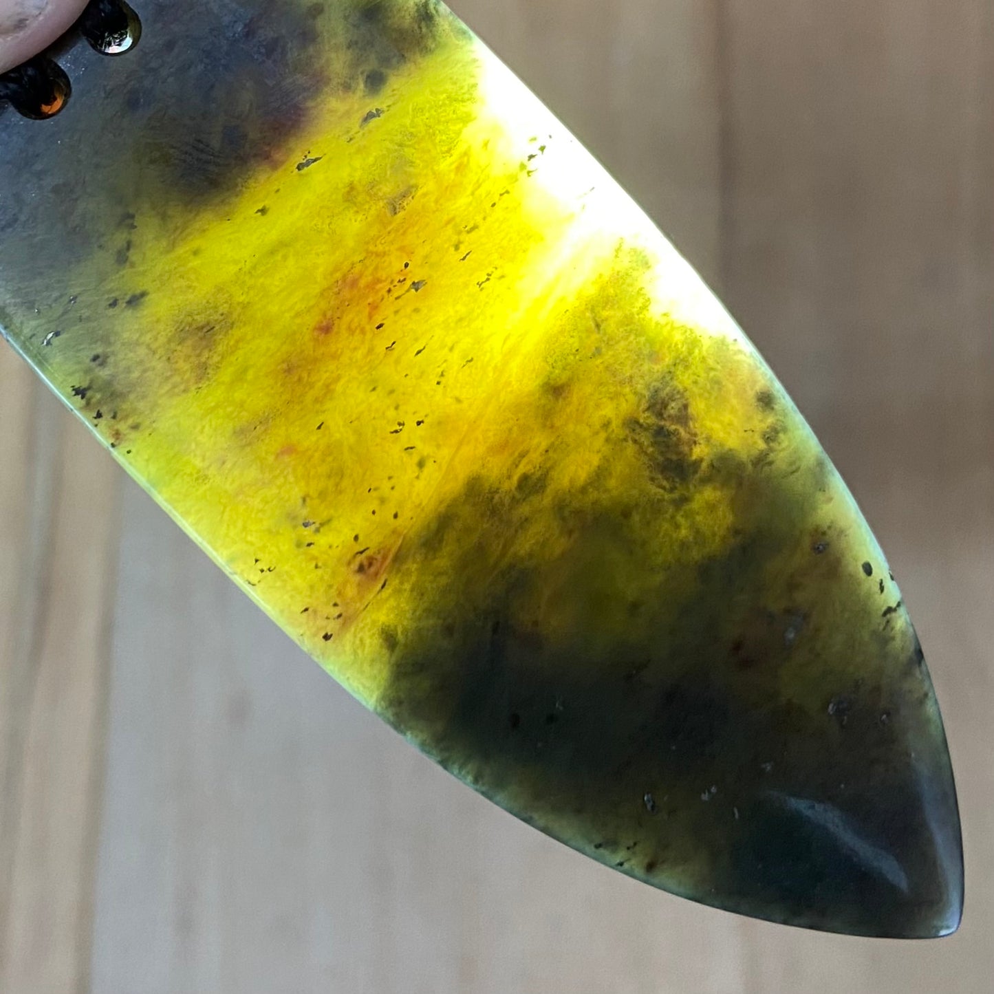 Bound Niho Tooth pendant hand-carved from New Zealand Kawakawa pounamu (greenstone). Translucency.