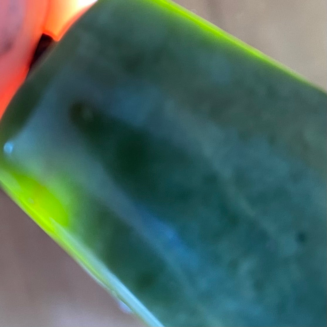 Pounamu toki pendant hand-carved from New Zealand Marsden Flower Jade pounamu (greenstone). Translucency.