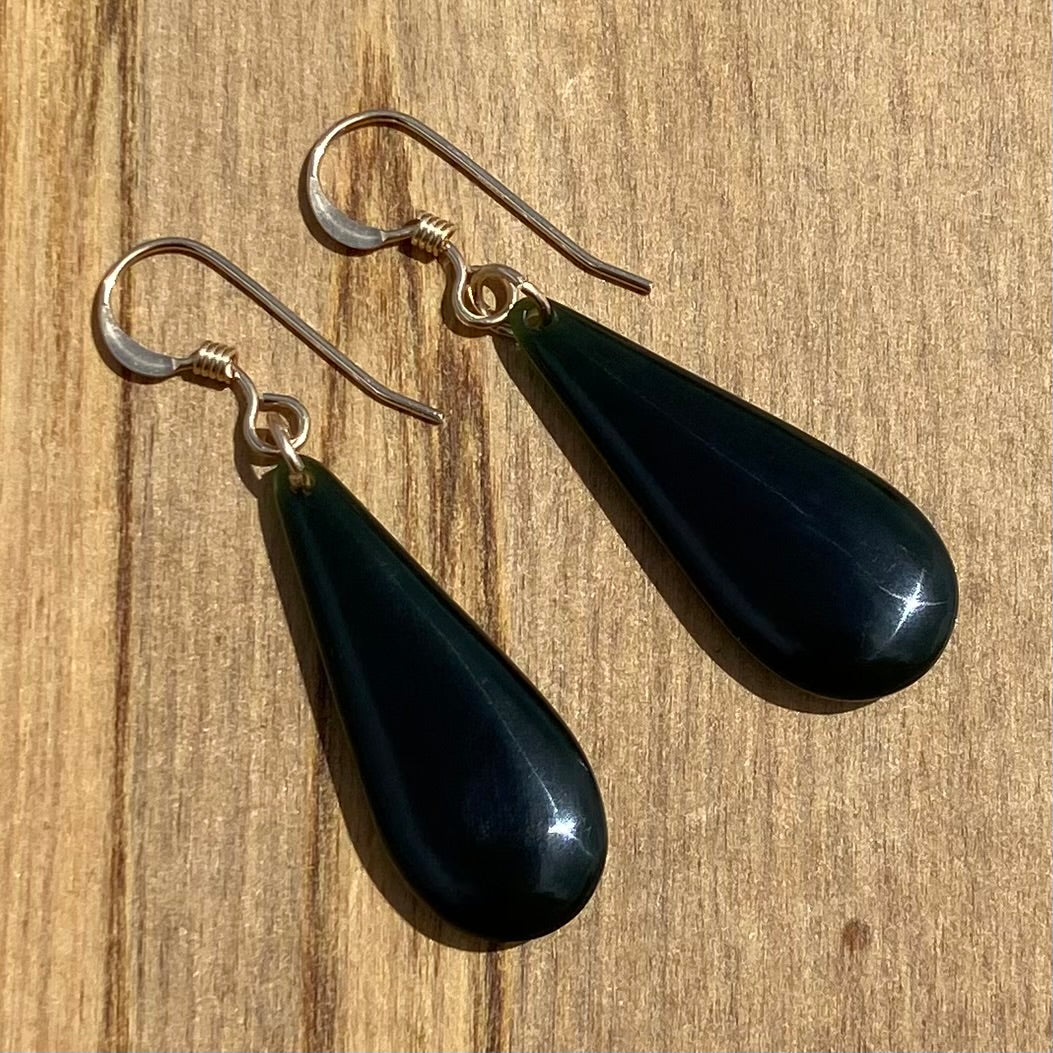 Pair of roimata (teardrop) earrings hand-carved from New Zealand Kawakawa Jade/ pounamu (greenstone), with gold fittings. Front.