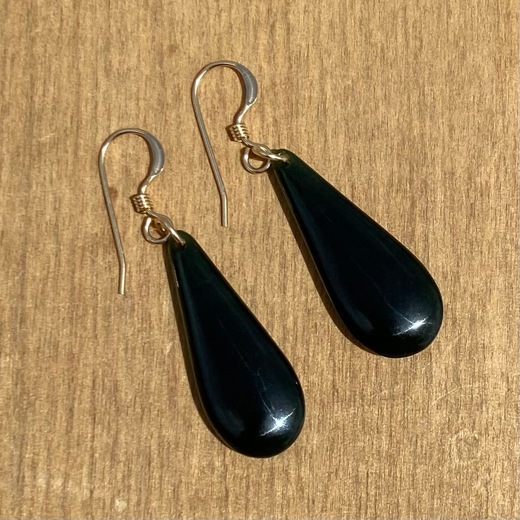 Pair of roimata (teardrop) earrings hand-carved from New Zealand Kawakawa Jade/ pounamu (greenstone), with gold fittings. Back.