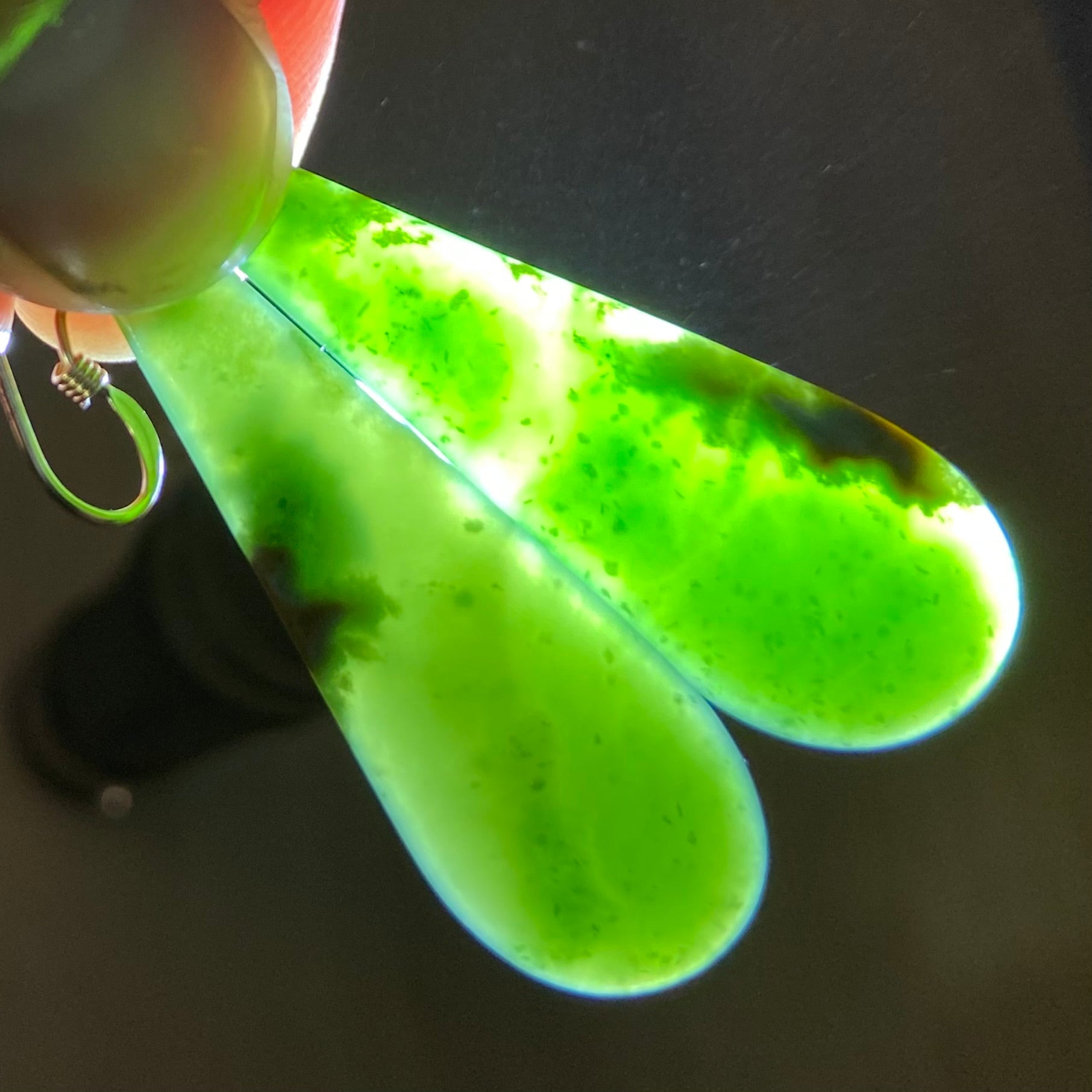 Pair of roimata (teardrop) earrings hand-carved from New Zealand Marsden Flower Jade/ pounamu (greenstone), with gold fittings. Translucency.