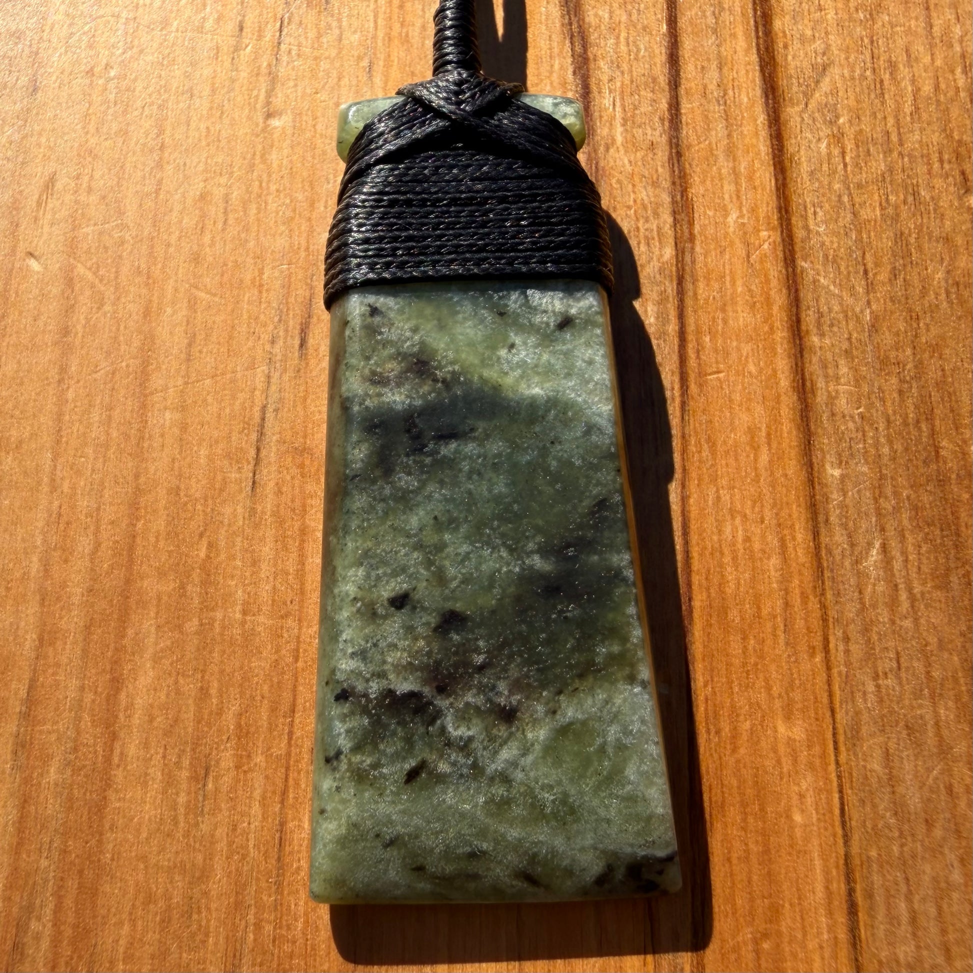 Bound toki pendant hand-carved from NZ Kawakawa pounamu (greenstone). Front.