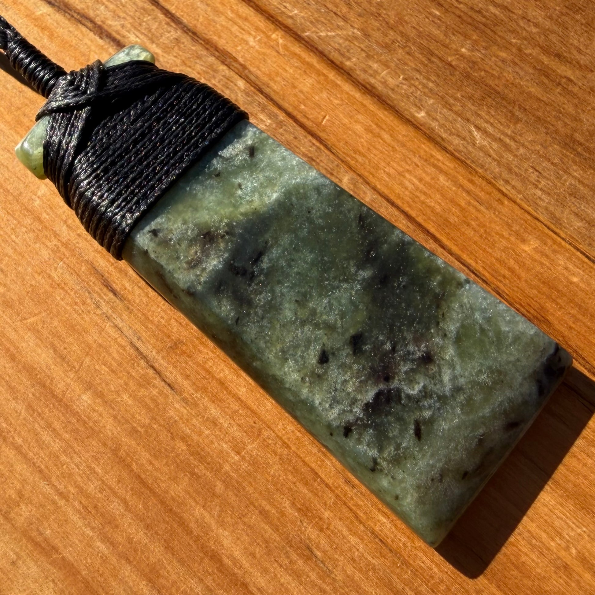 Bound toki pendant hand-carved from NZ Kawakawa pounamu (greenstone). Front.