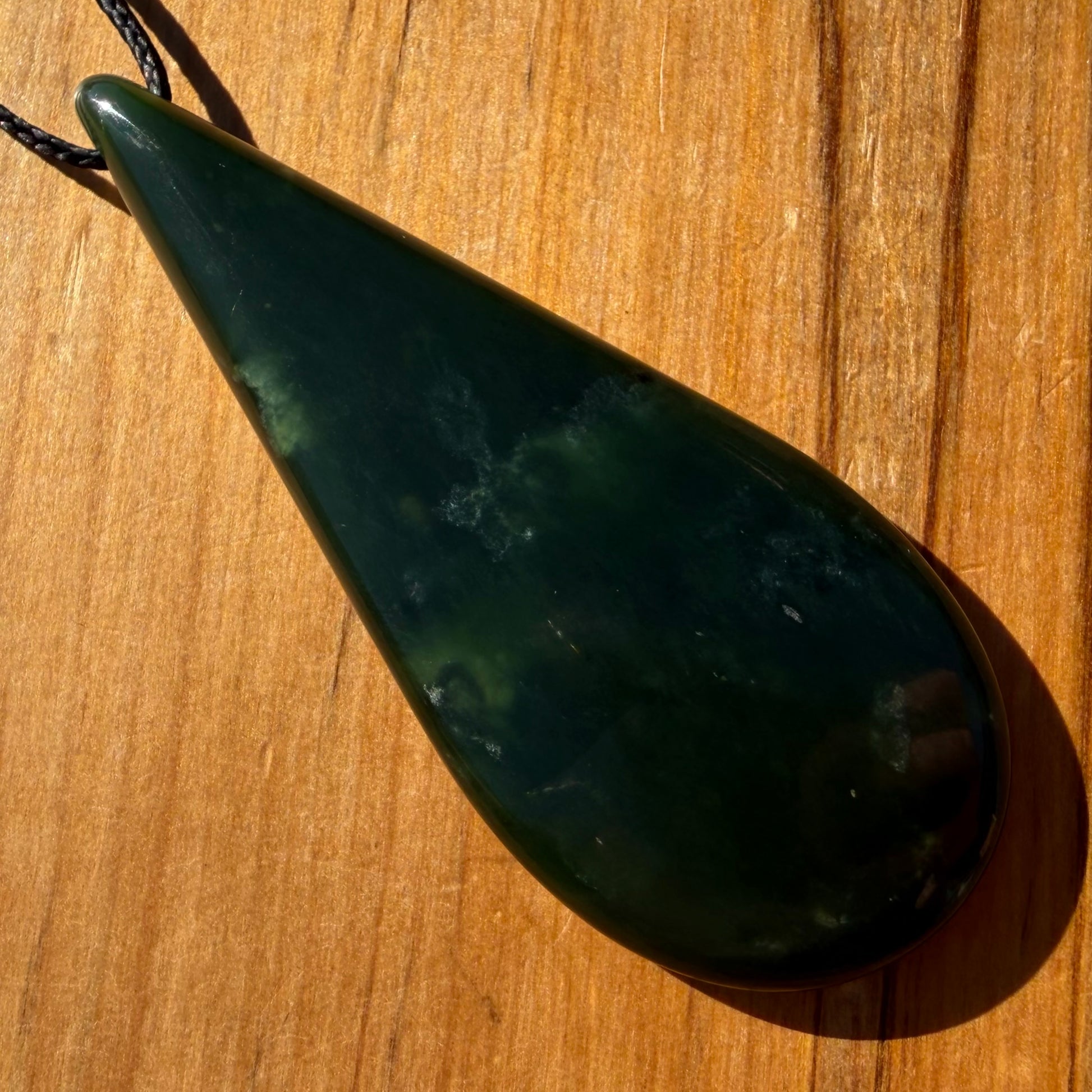 Roimata pendant hand-carved from New Zealand kawawkawa pounamu (greenstone). Front.