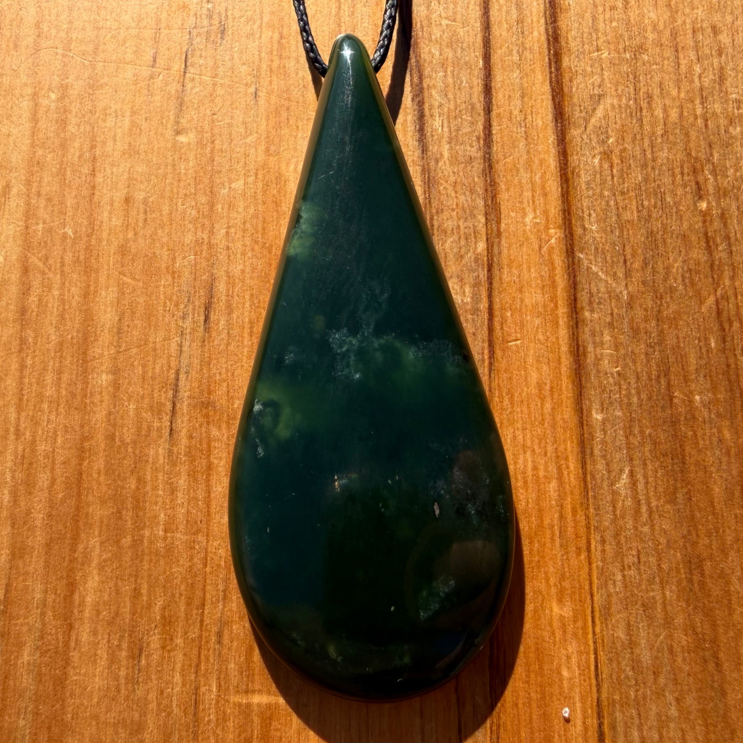Roimata pendant hand-carved from New Zealand kawawkawa pounamu (greenstone). Front.