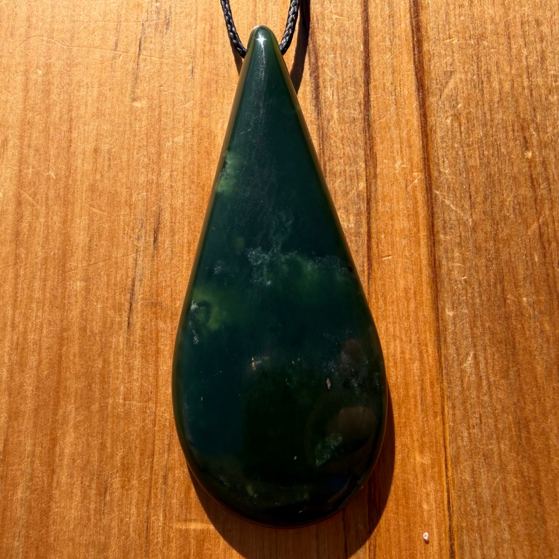 Roimata pendant hand-carved from New Zealand kawawkawa pounamu (greenstone). Front.