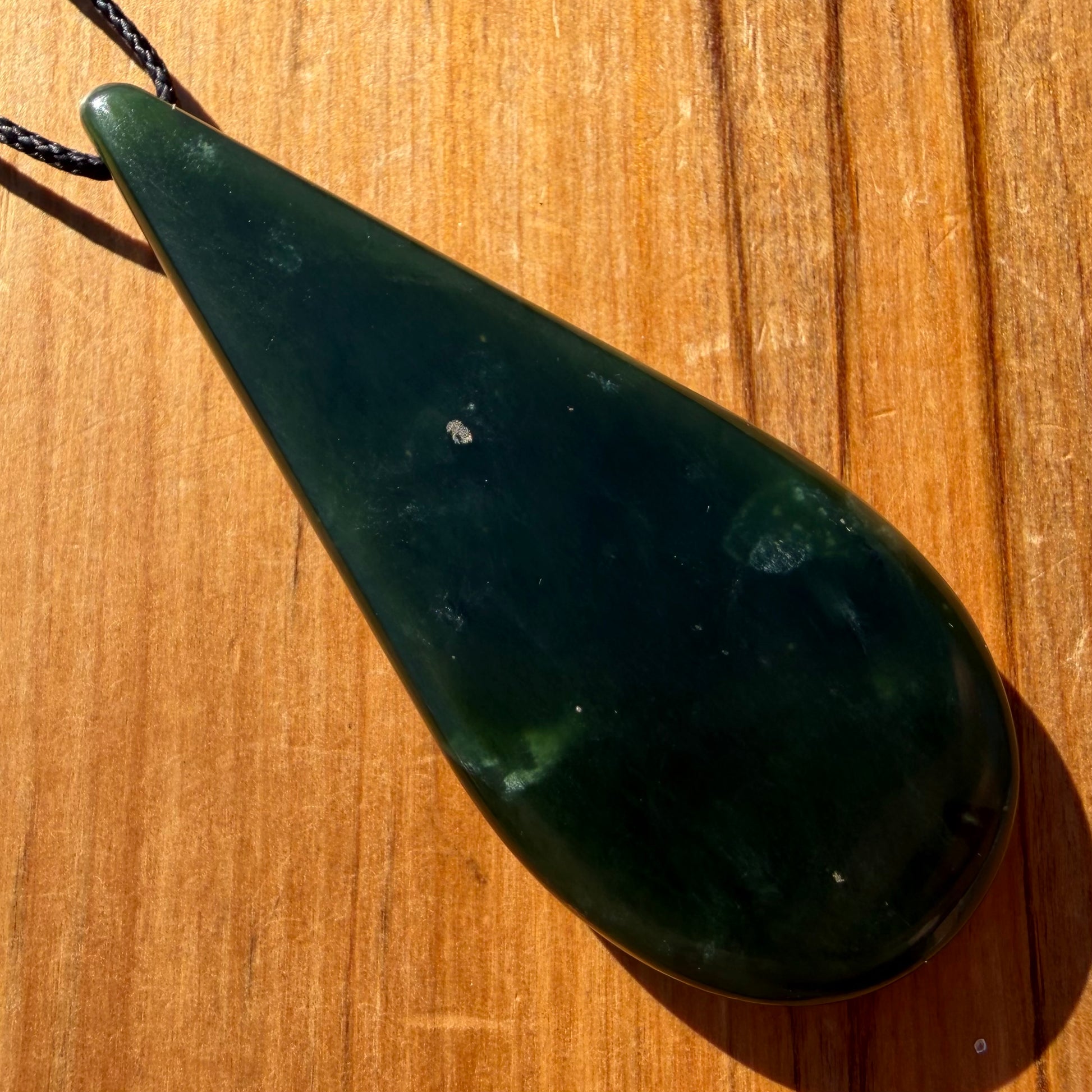 Roimata pendant hand-carved from New Zealand kawawkawa pounamu (greenstone). Back.