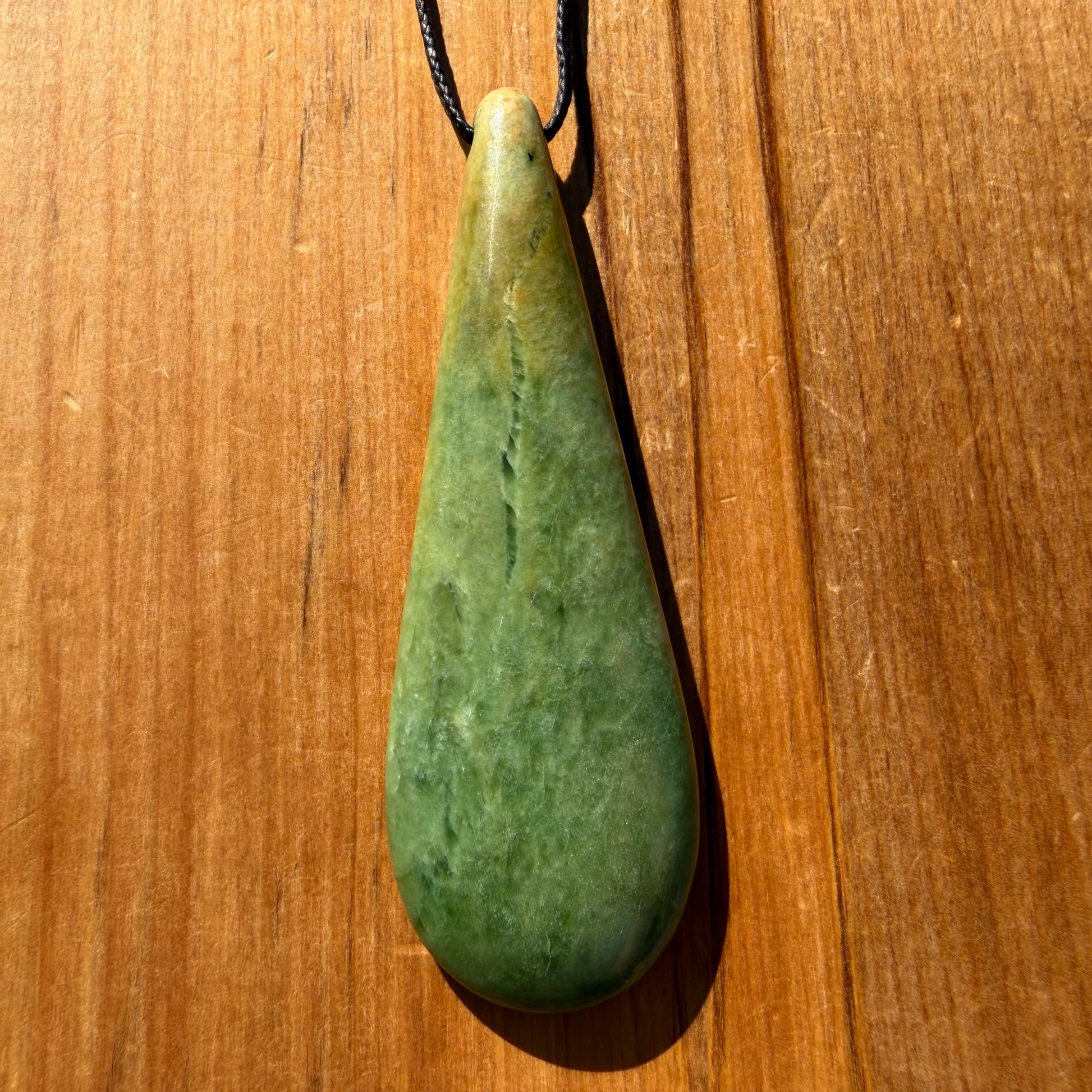Roimata (teardrop) pendant hand-carved from New Zealand Marsden Flower Jade/ pounamu (greenstone). Front.