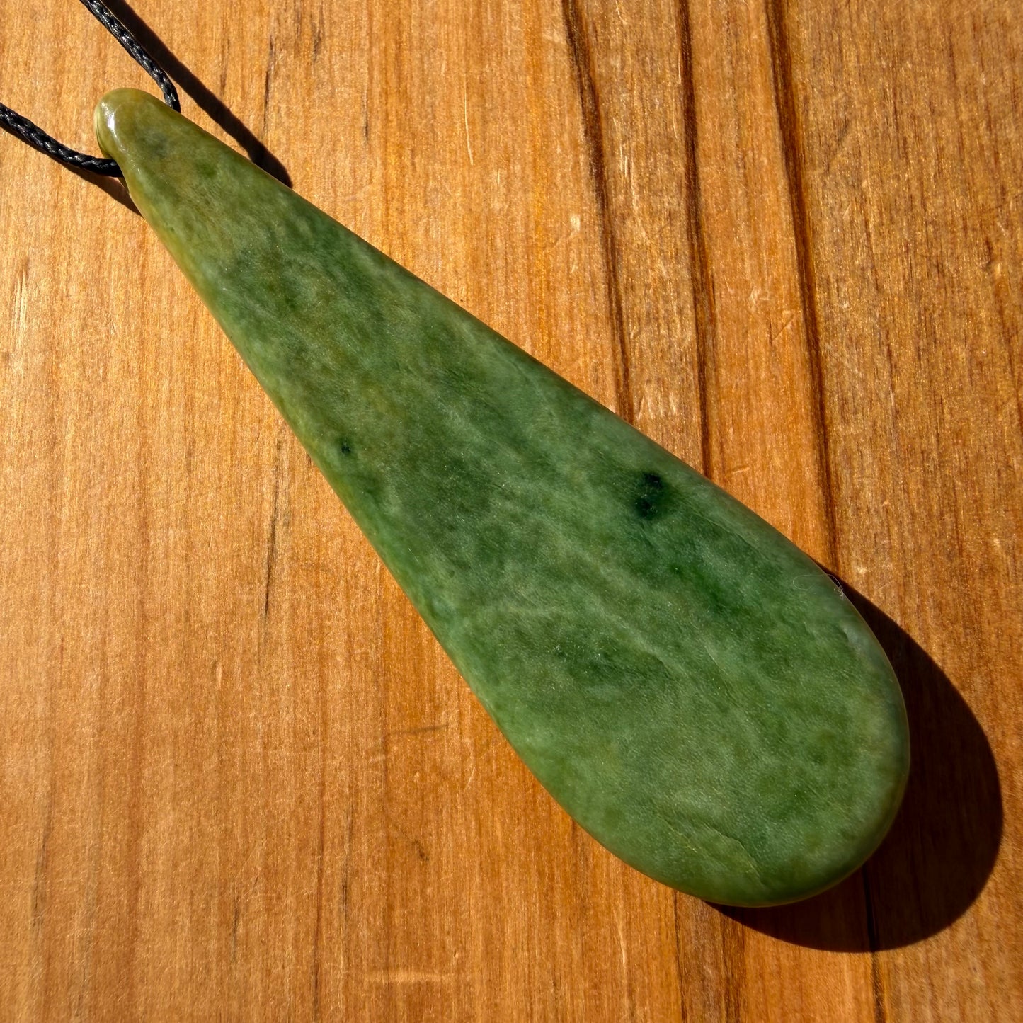 Roimata (teardrop) pendant hand-carved from New Zealand Marsden Flower Jade/ pounamu (greenstone). Back.