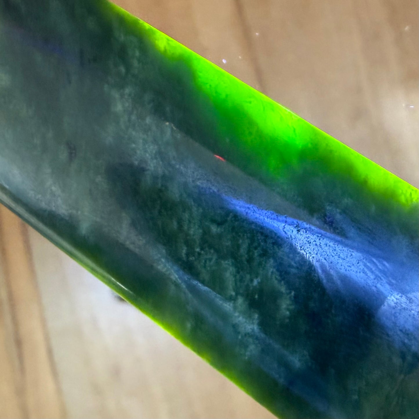 Pounamu toki pendant hand-carved from New Zealand Marsden Flower Jade pounamu (greenstone). Translucency.