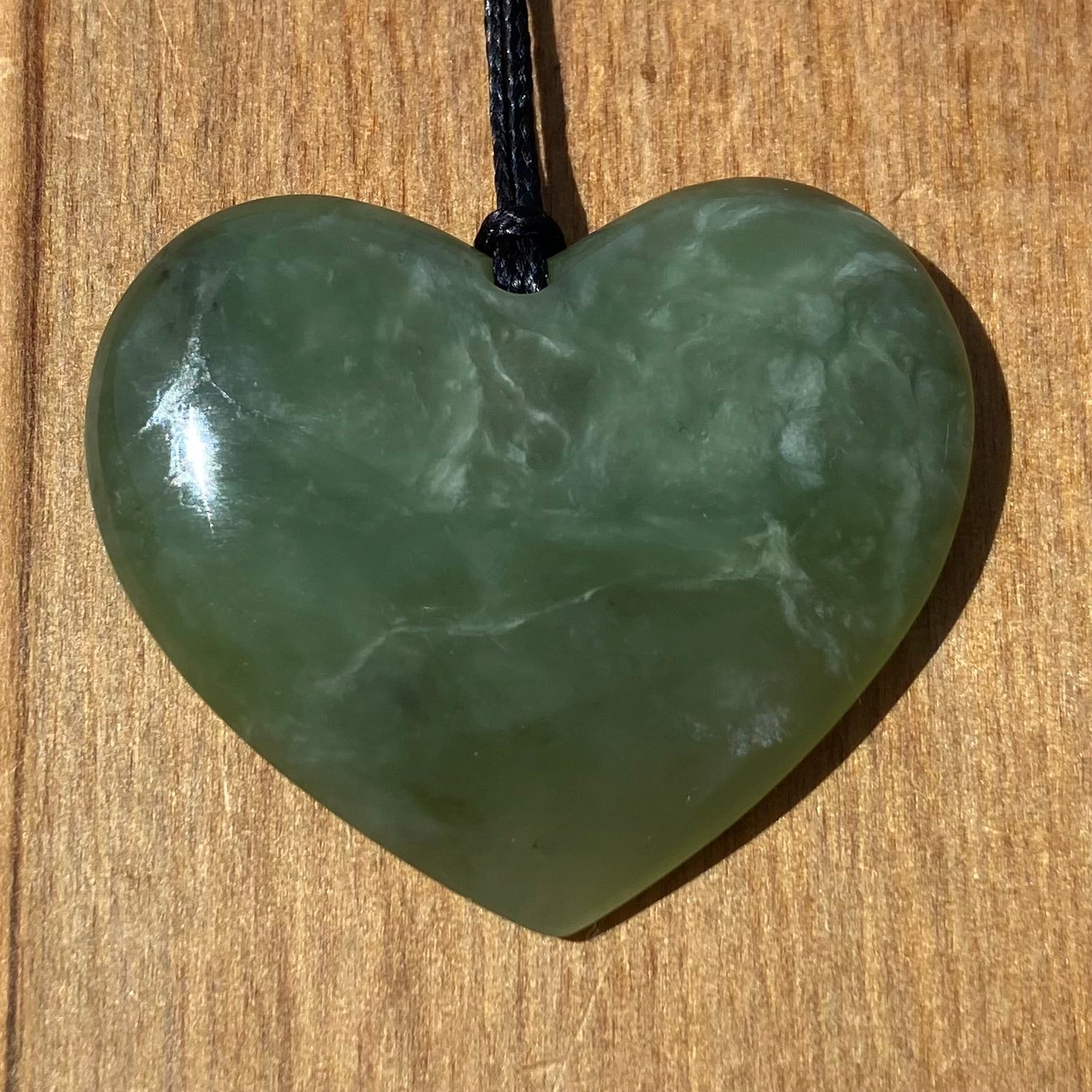 Heart necklace hand-carved from New Zealand pounamu (greenstone) Kahurangi. Front.