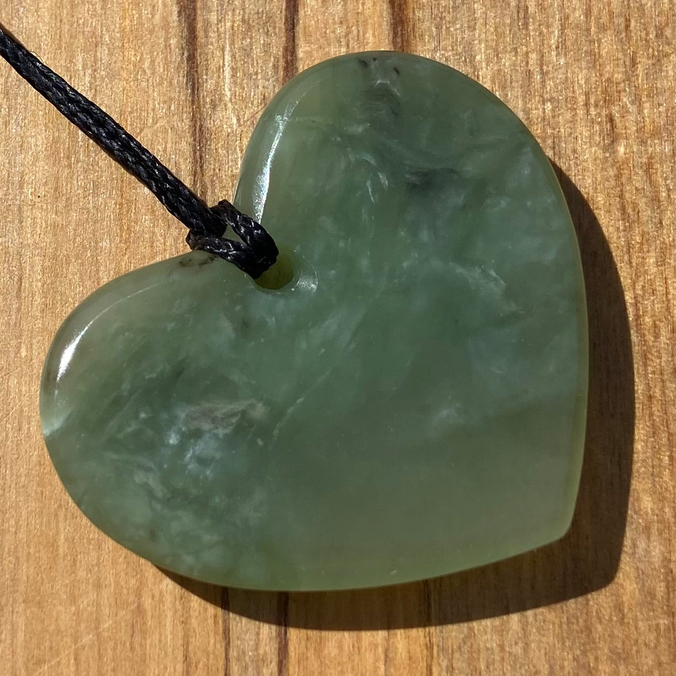 Heart necklace hand-carved from New Zealand pounamu (greenstone) Kahurangi. Back. 