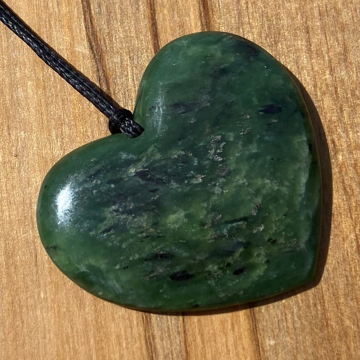 Heart necklace hand-carved from NZ kawakawa pounamu (greenstone). Front.