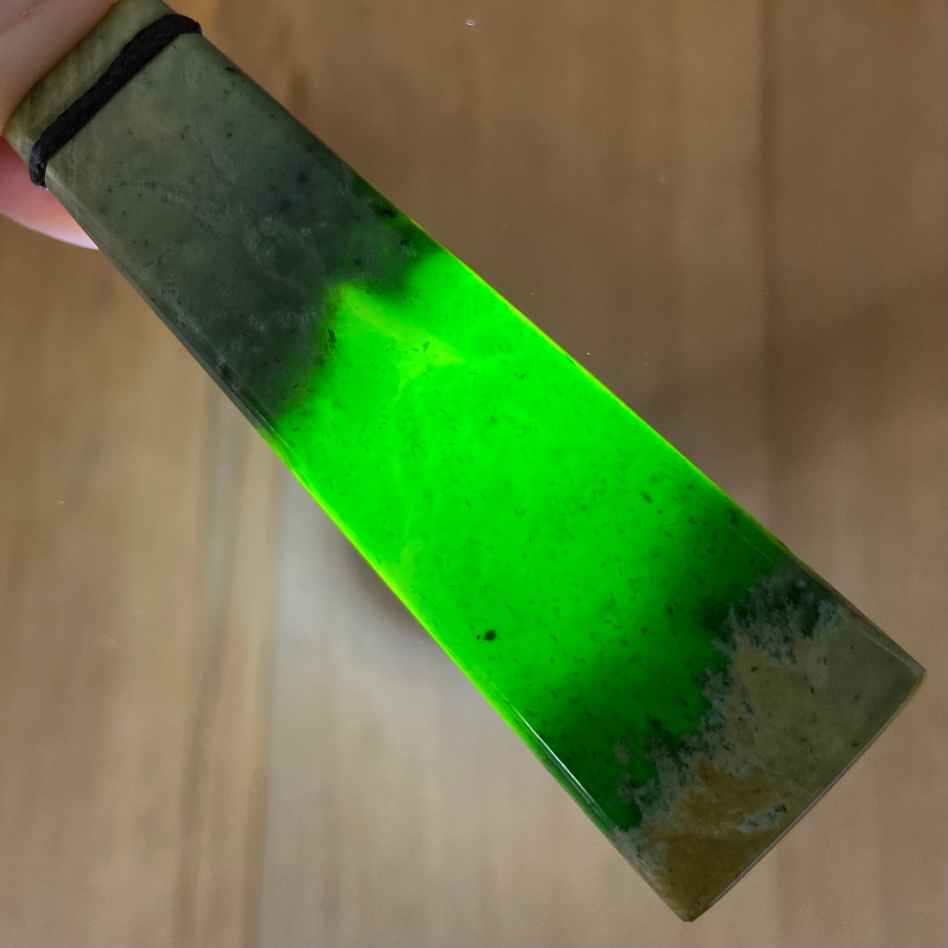 Pounamu toki pendant hand-carved from New Zealand Marsden Flower Jade pounamu (greenstone). Translucency.