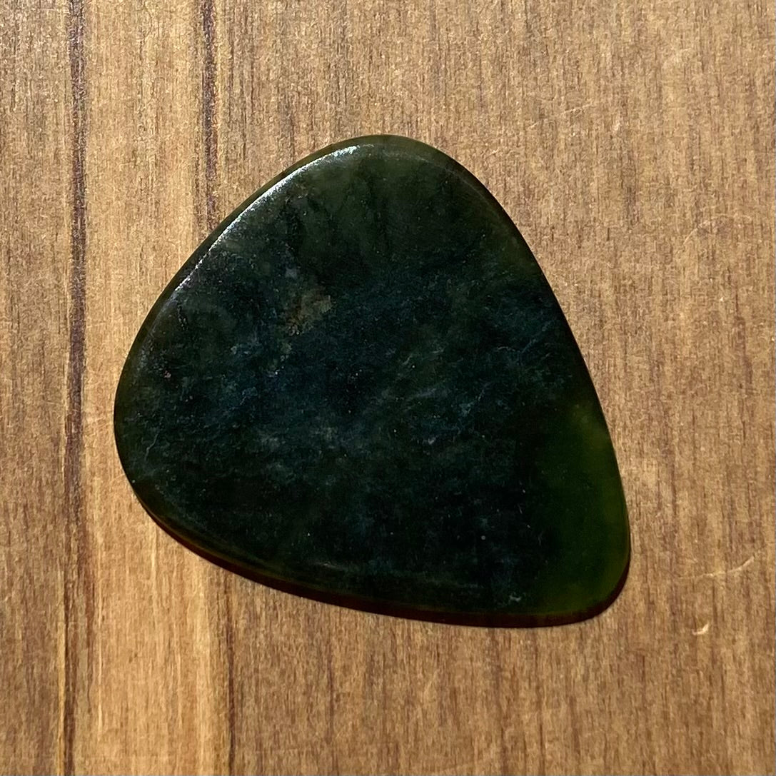 Guitar pick hand-carved from New Zealand Kawakawa Greenstone pounamu (greenstone). Back.