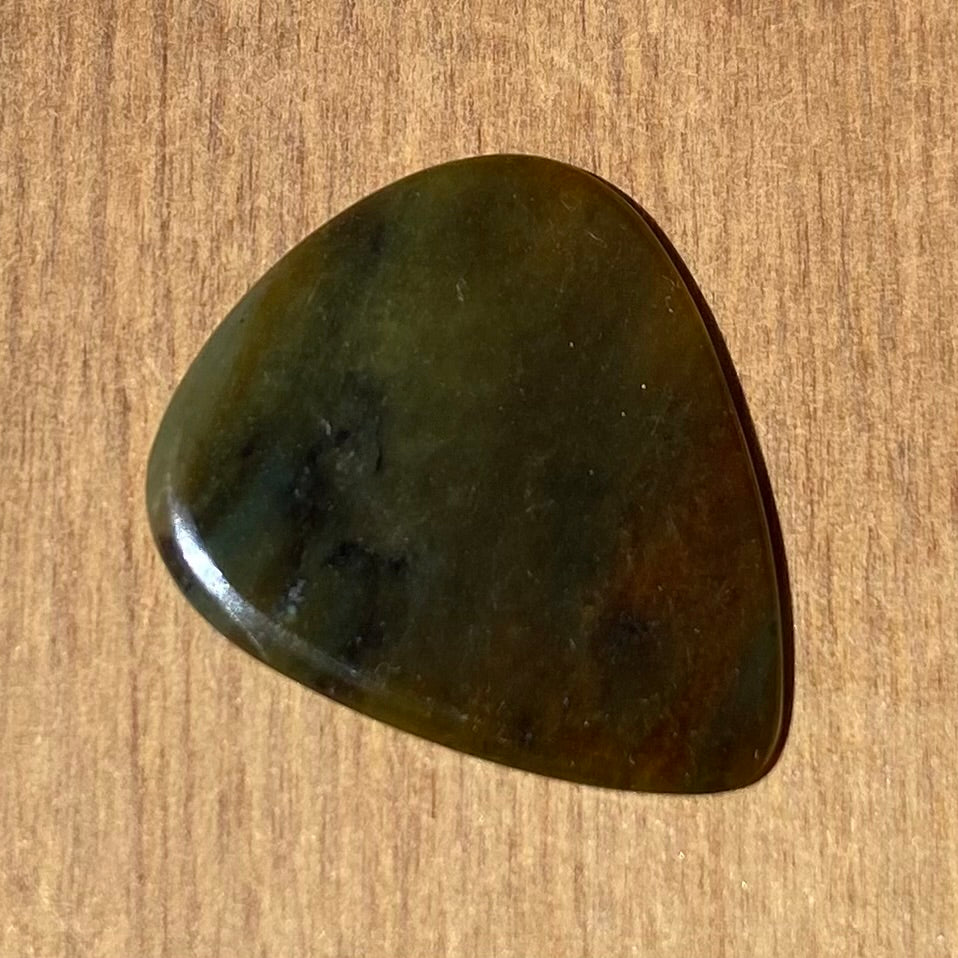 Guitar pick hand-carved from New Zealand Totoweka Greenstone pounamu (greenstone). Front.